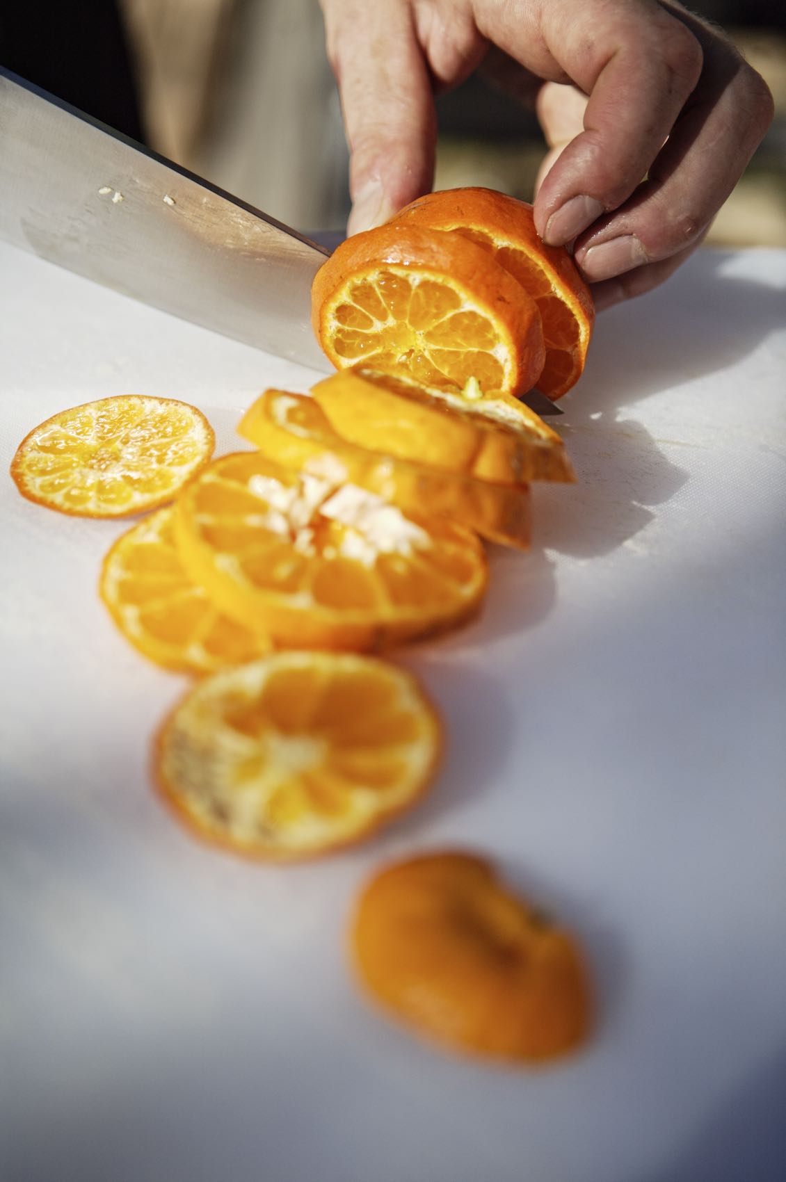 Jody Horton Photography - Orange being sliced on a cutting board.