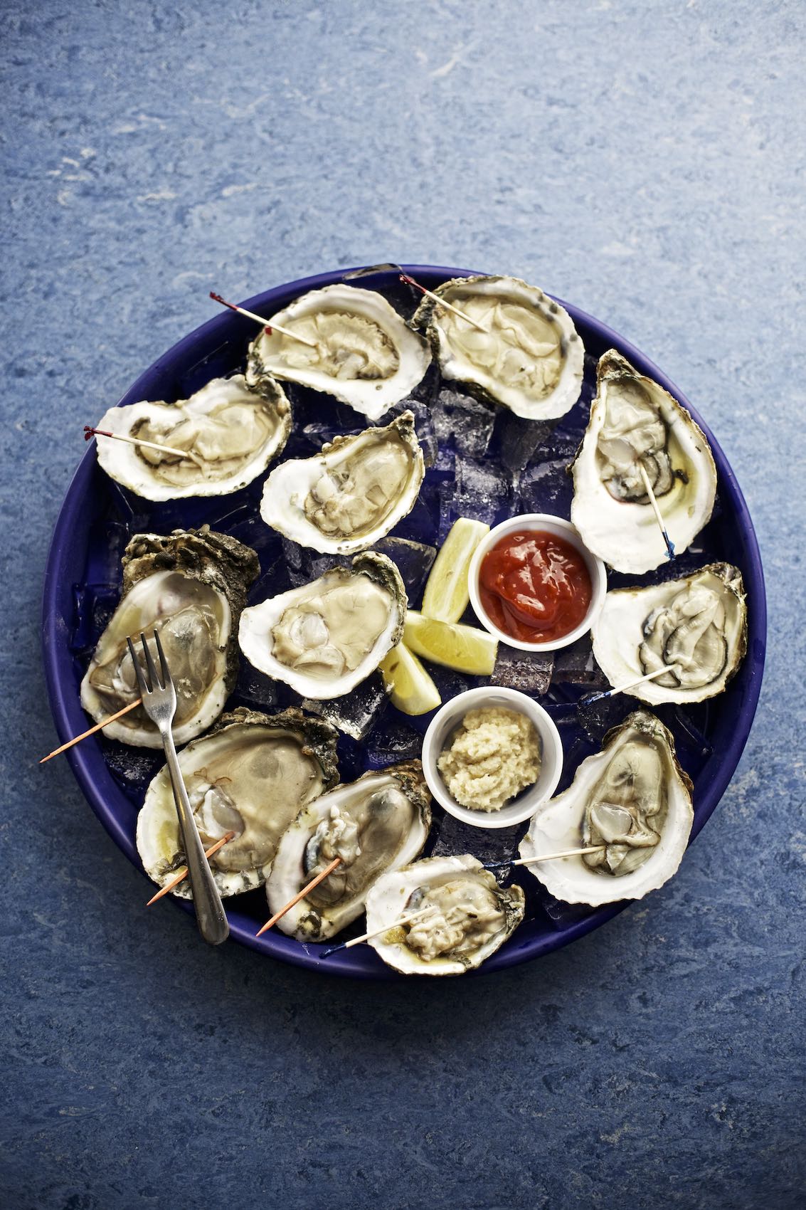 Jody Horton Photography - Dozen raw oysters on ice with dressings.
