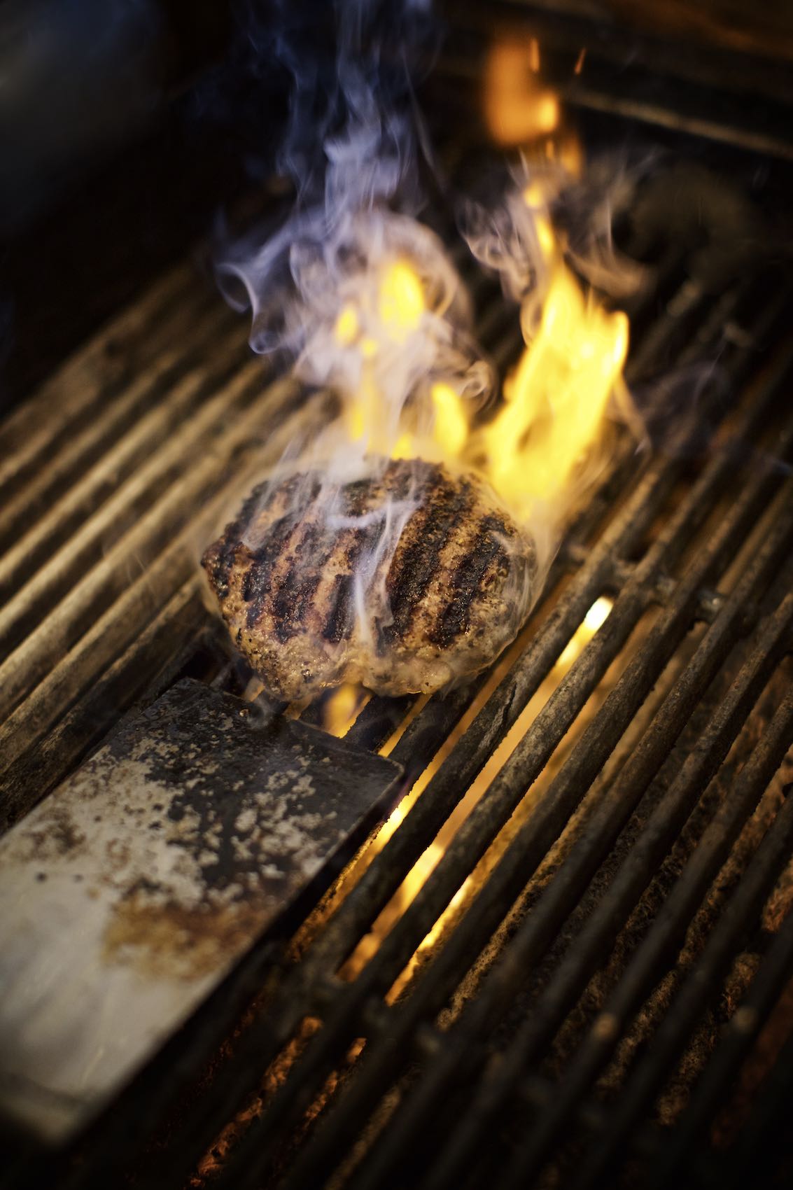 Jody Horton Photography - Single burger patty cooking on wood fired grill. 
