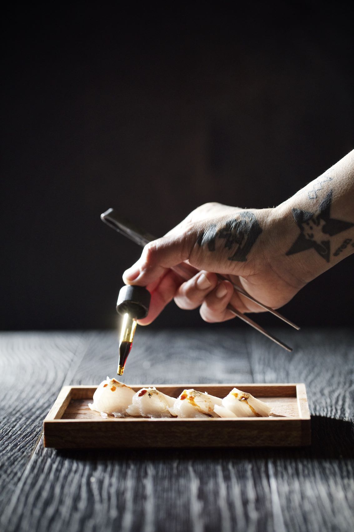 Jody Horton Photography - Chef hand distributing sauce to a sashimi dish. 