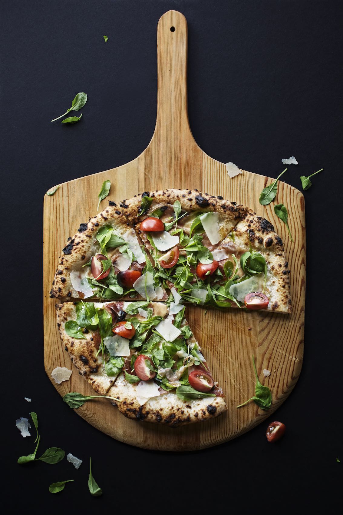 Jody Horton Photography - Colorful, vegetable pizza missing a slice on a wood pizza peel.