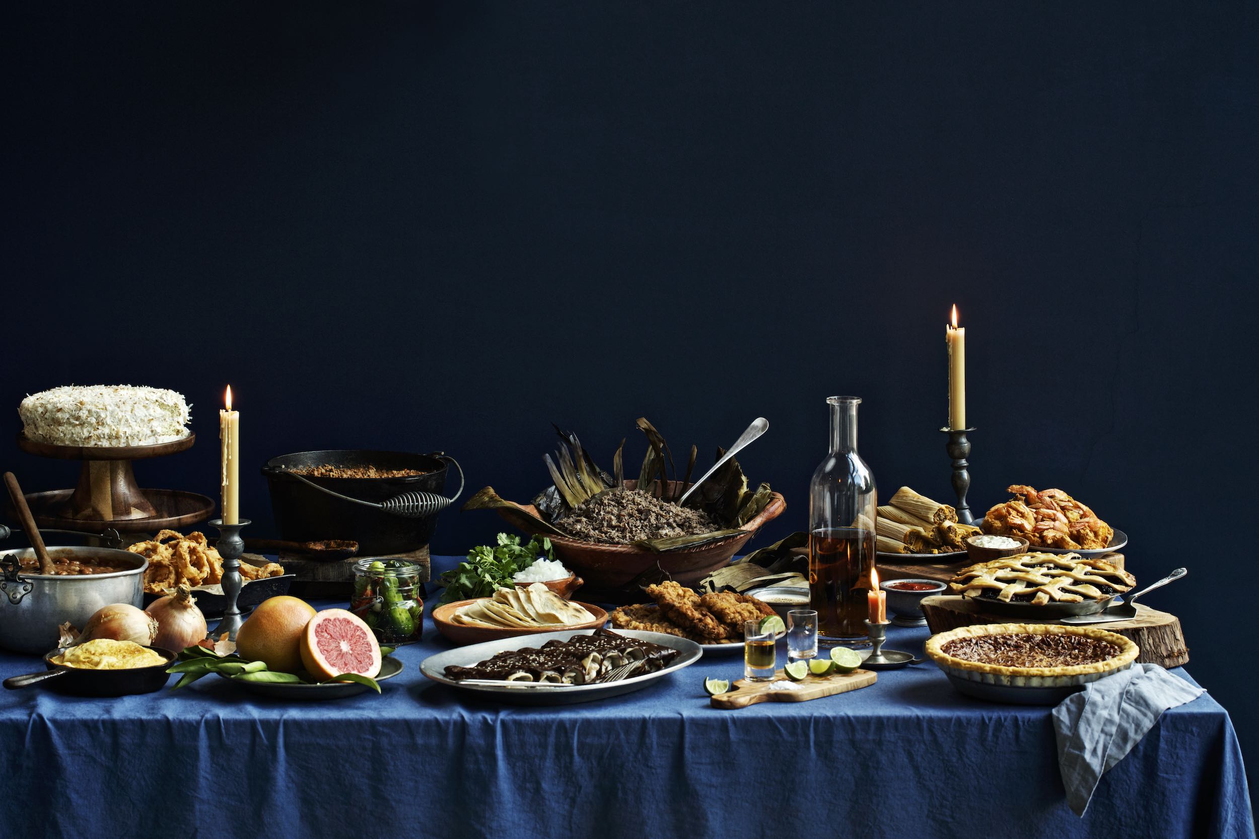 Jody Horton Photography - Candlelit dinner spread on blue table cloth, against dark blue wall. 