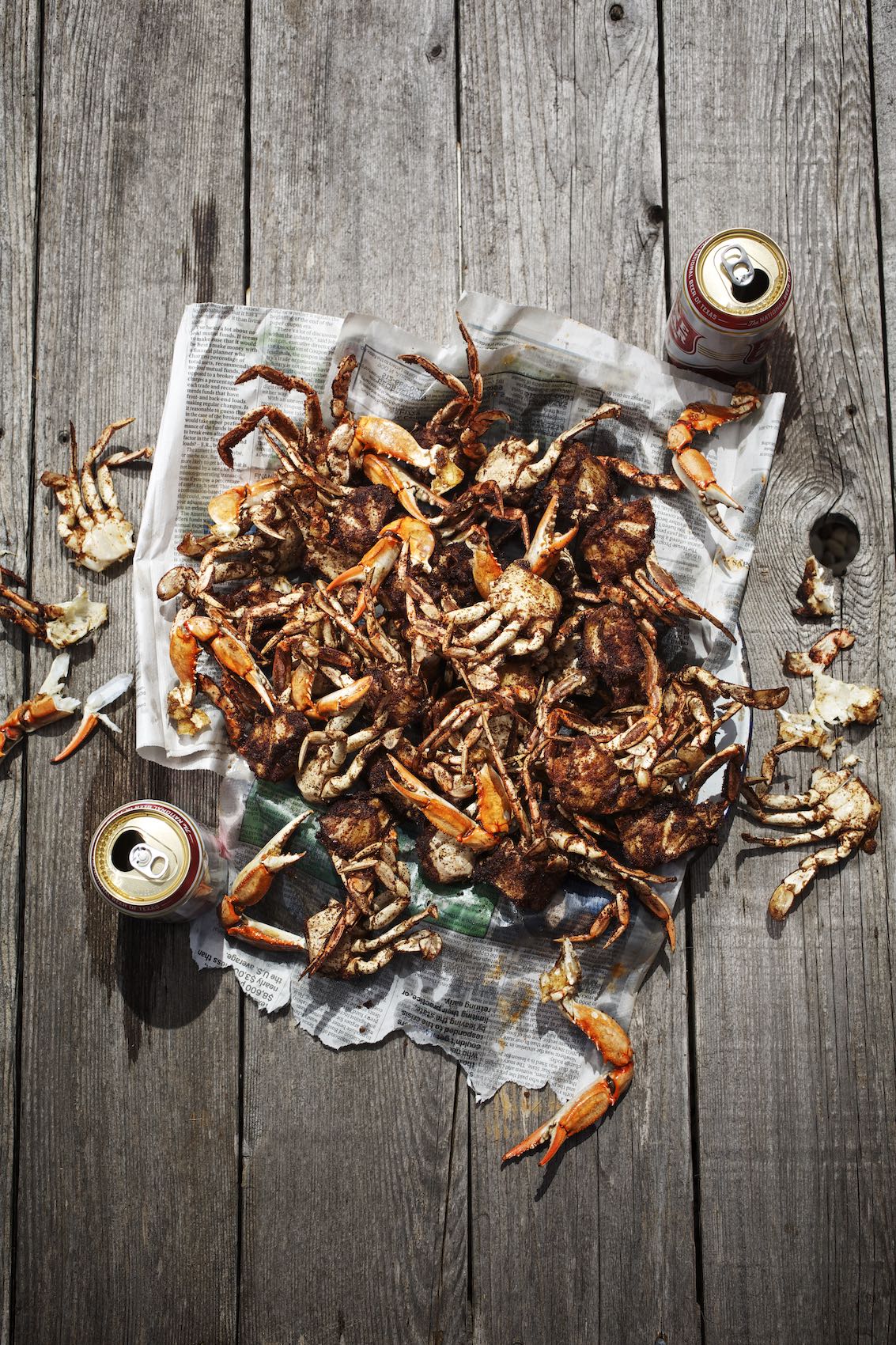 Jody Horton Photography - Crab claws and Lonestar on newspapers, on a wood surface. 