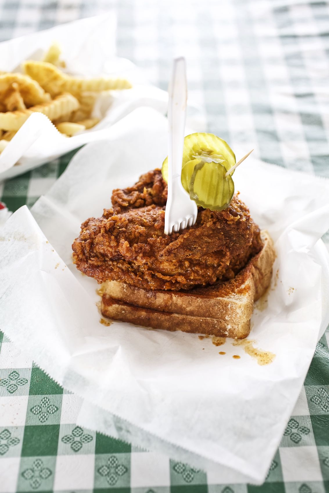 Jody Horton Photography - Fried chicken with bread and pickles on checkered picnic table. 