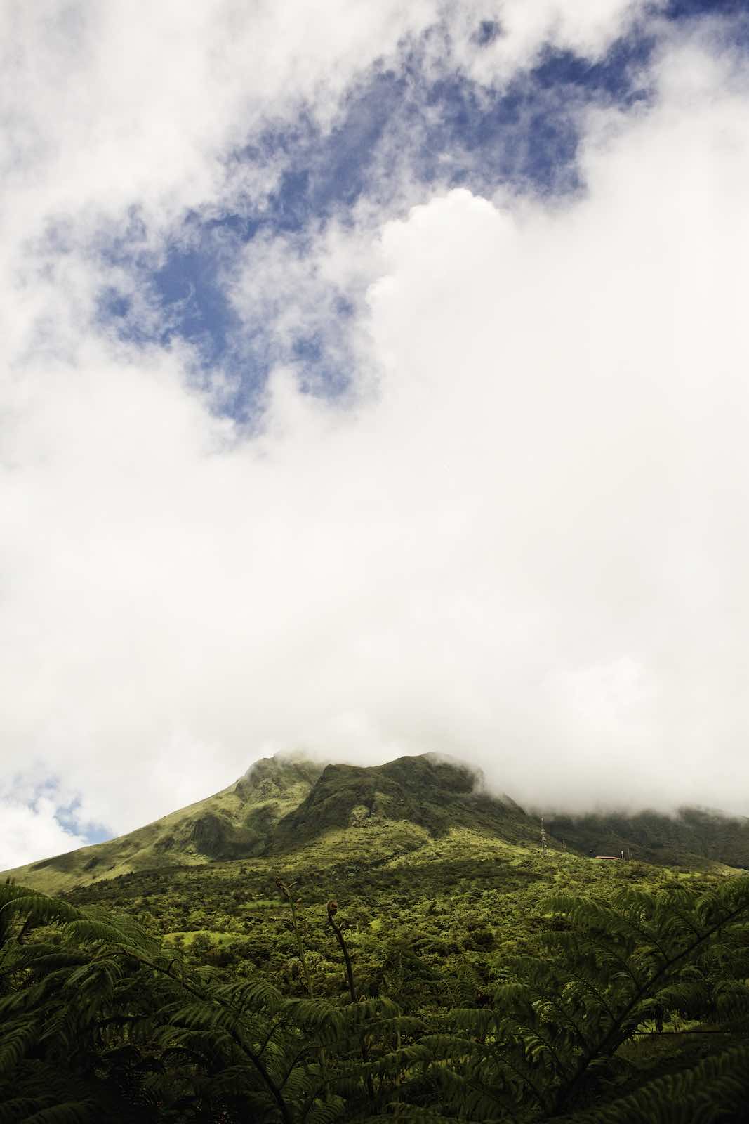 Jody Horton Photography - A lush and tropical mountain with low clouds covering the top. 