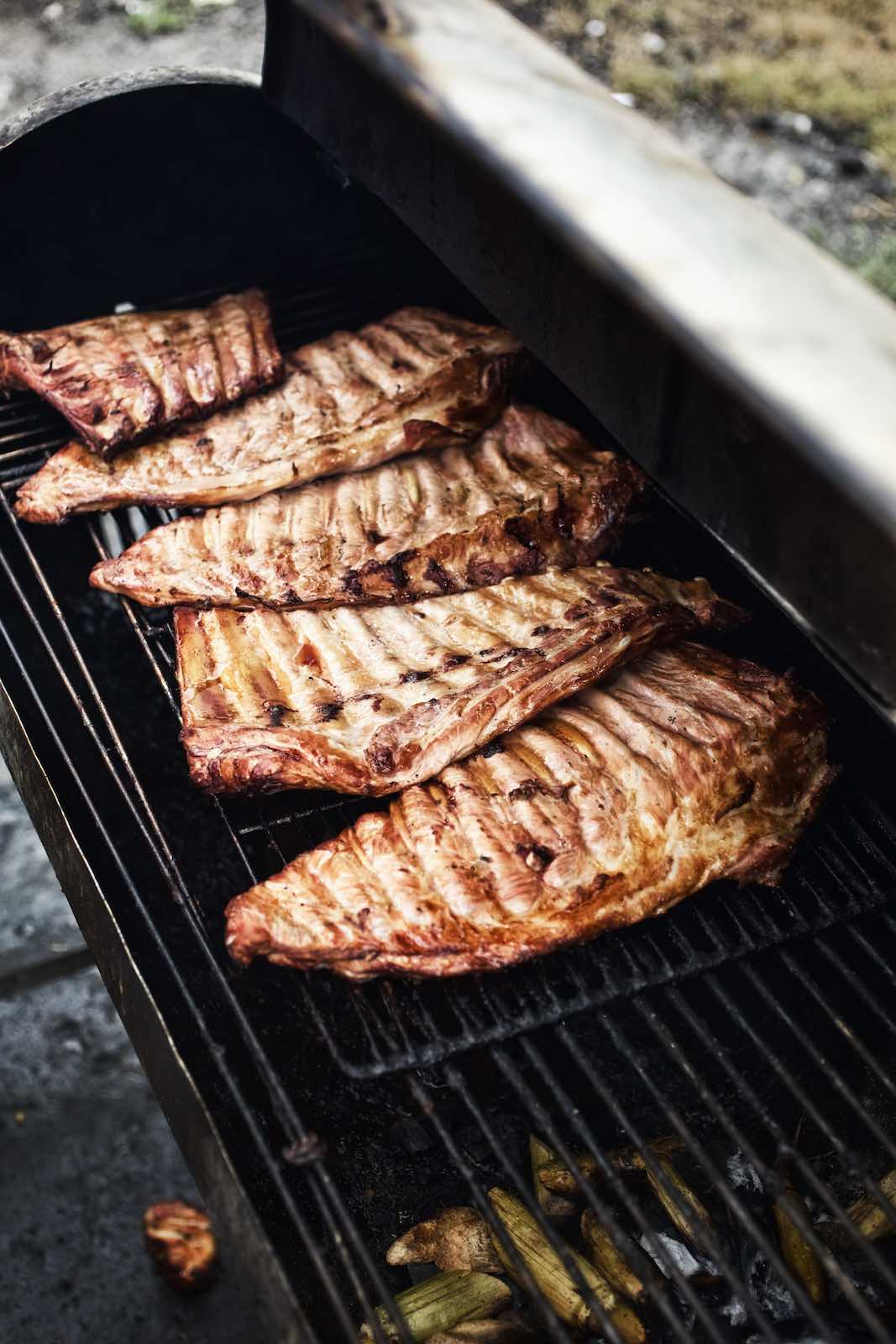 Jody Horton Photography - Racks of ribs cooking on a grill. 