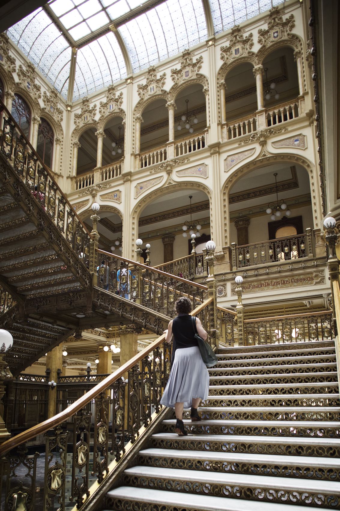 Jody Horton Photography - Woman climbing a golden staircase in Mexico City. 
