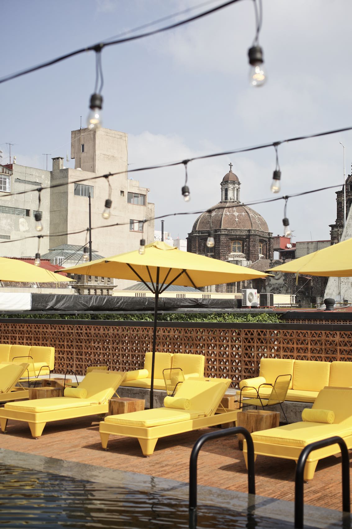 Jody Horton Photography - Hotel pool with vibrant yellow furniture in Mexico City. 