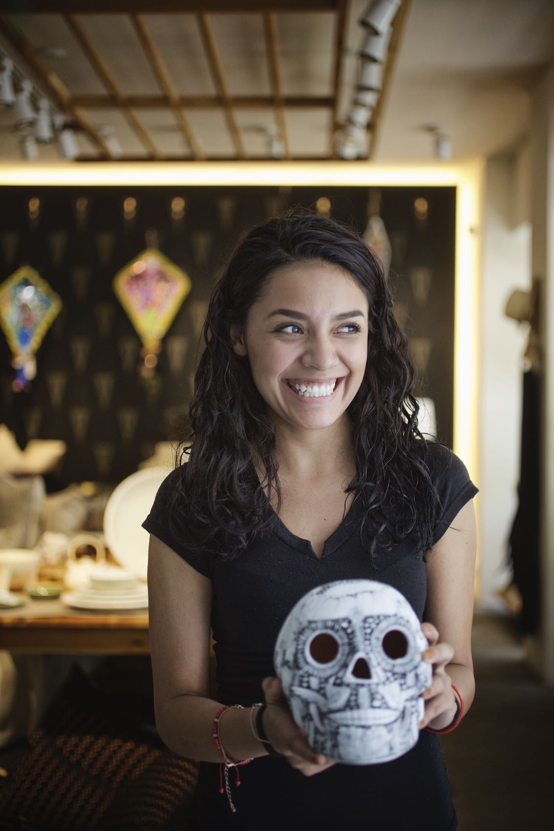 Jody Horton Photography - Young woman smiling and holding a  decorative skull. 