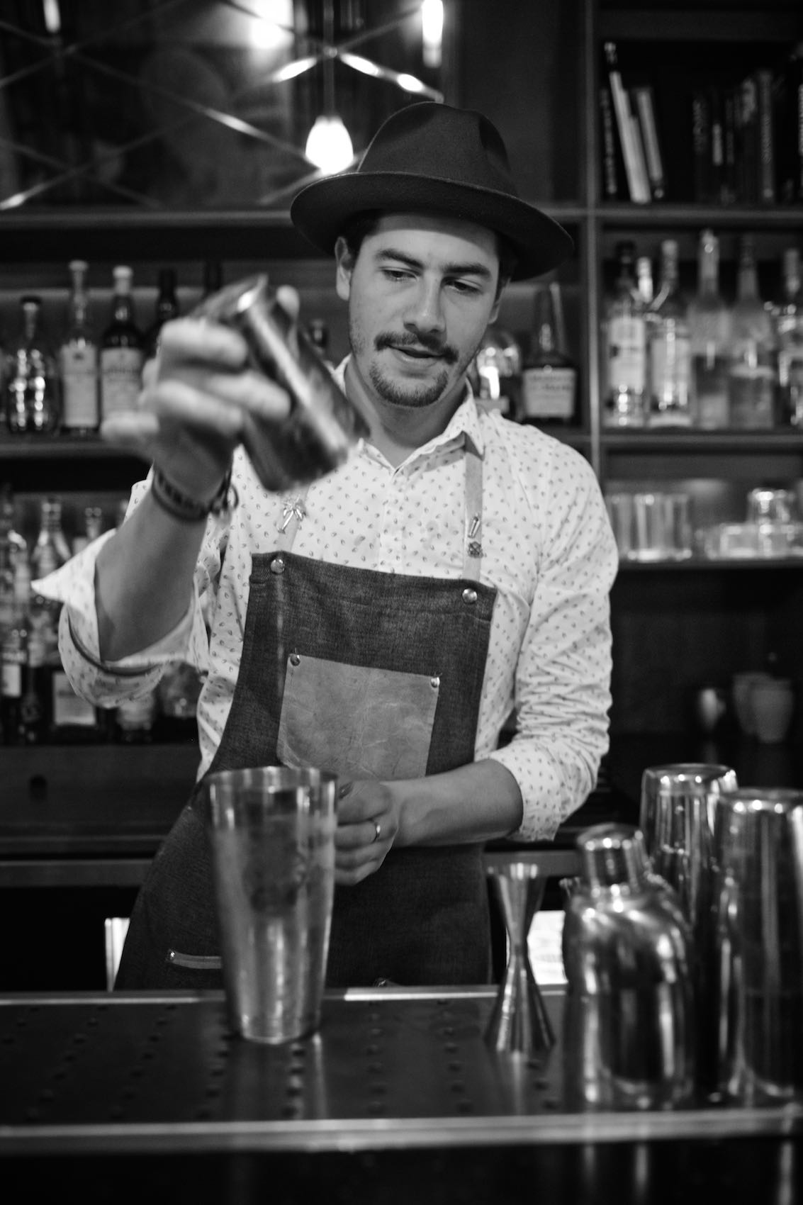 Jody Horton Photography - Bartender preparing cocktails behind a bar, shot in B&W.