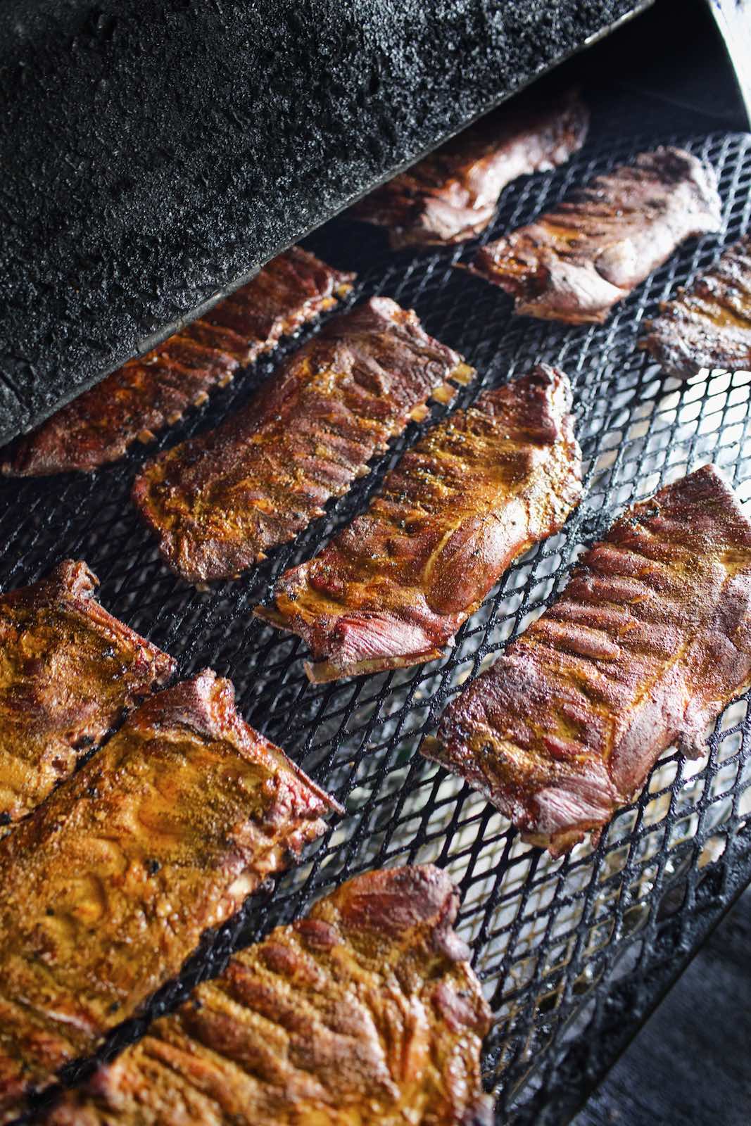 Jody Horton Photography - Racks of ribs cooking in a smoker. 