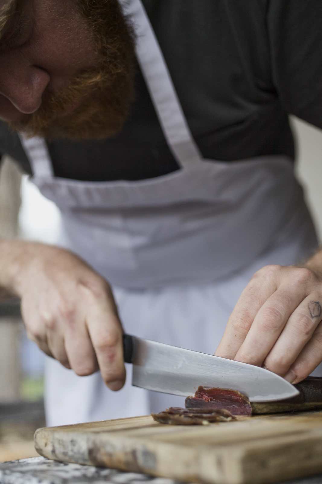 Jody Horton Photography - Chef Jesse cutting cured meat.