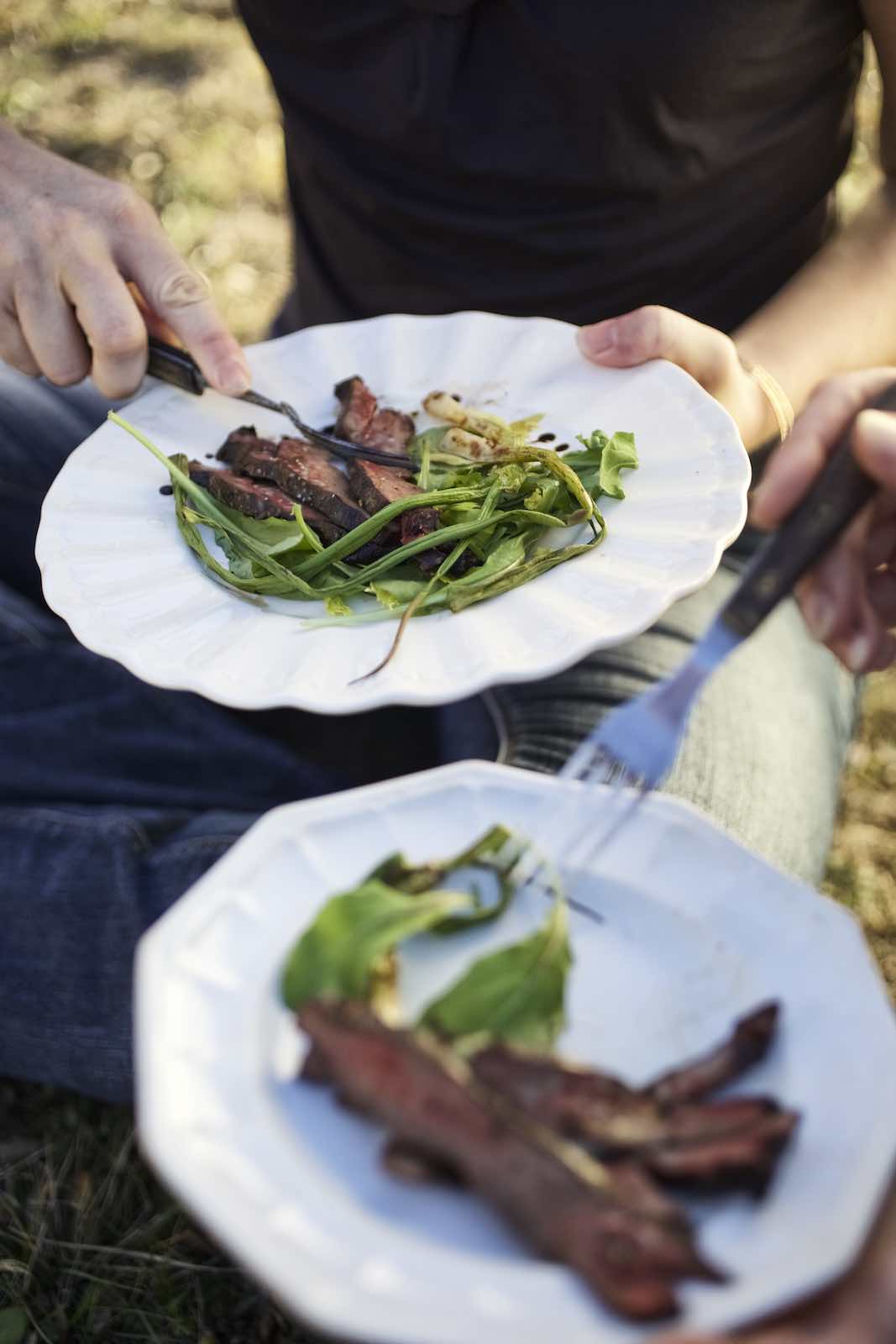 Jody Horton Photography - Cooked meat and greens enjoyed on white plates.