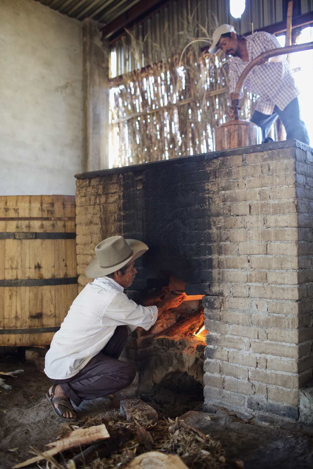Jody Horton Photography - Farmer building a large fire within a brick oven. 