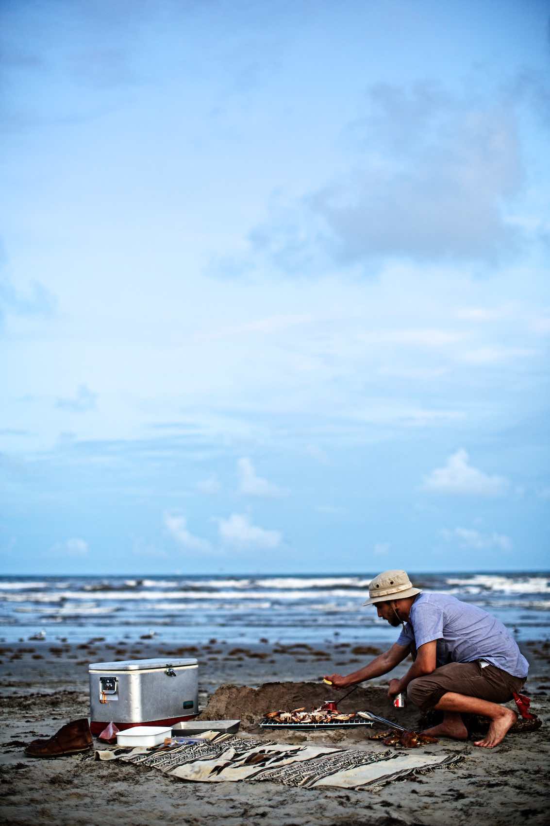 Jody Horton Photography - Cook preparing crab on a sandy beach.