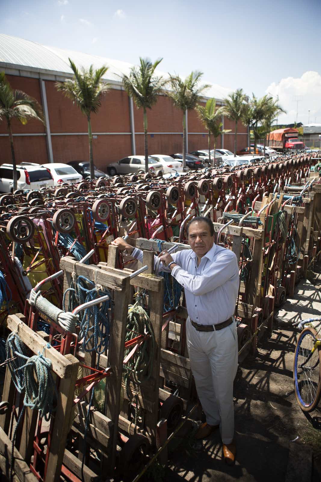 Jody Horton Photography - Man standing among rows of carts outside a Mexican food market. 