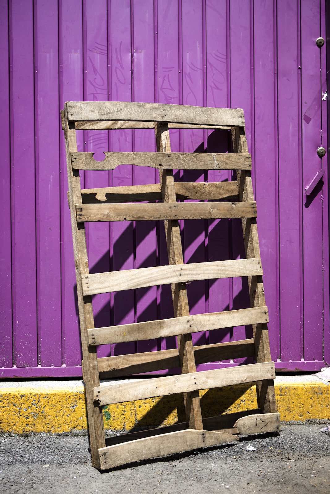 Jody Horton Photography - Wooden frame leaned up against a bright purple door. 