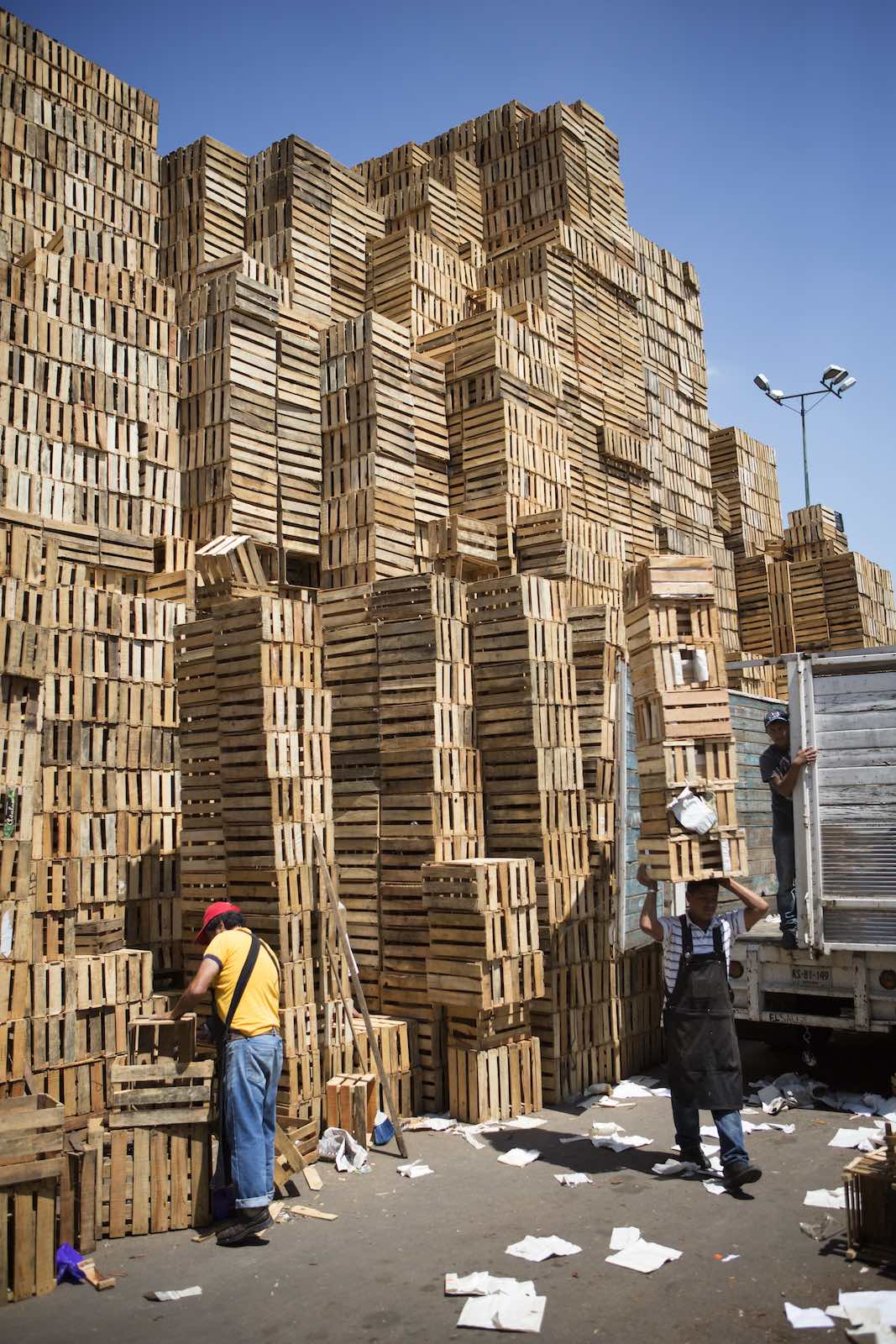 Jody Horton Photography - Men carrying crates from the towers of abandoned ones outside the market.