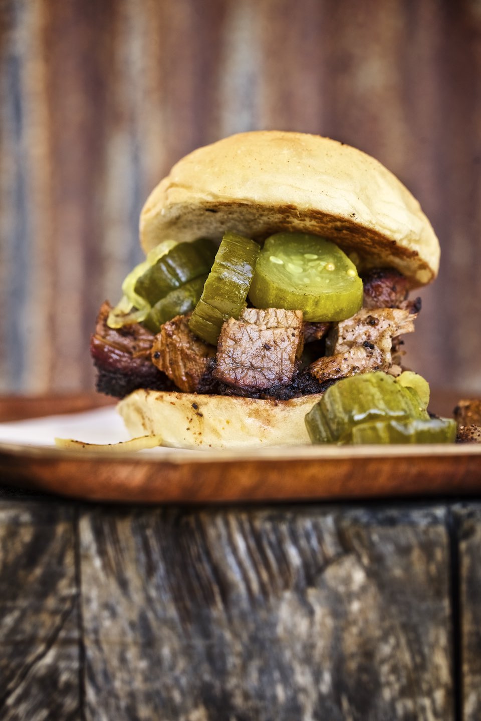 Barbecue sandwich with butter pickles on a wood table. 