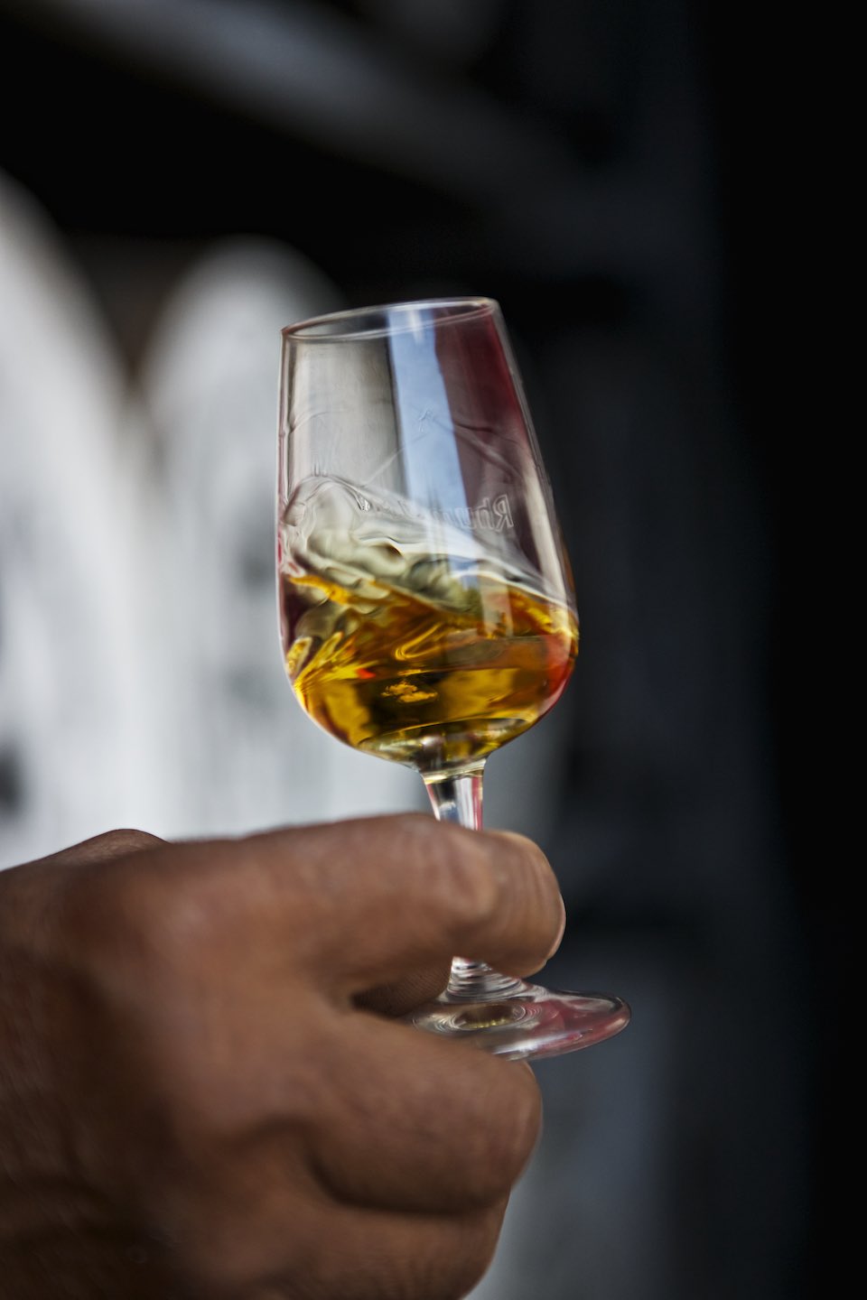 Golden rum swirling in a stemware glass. 