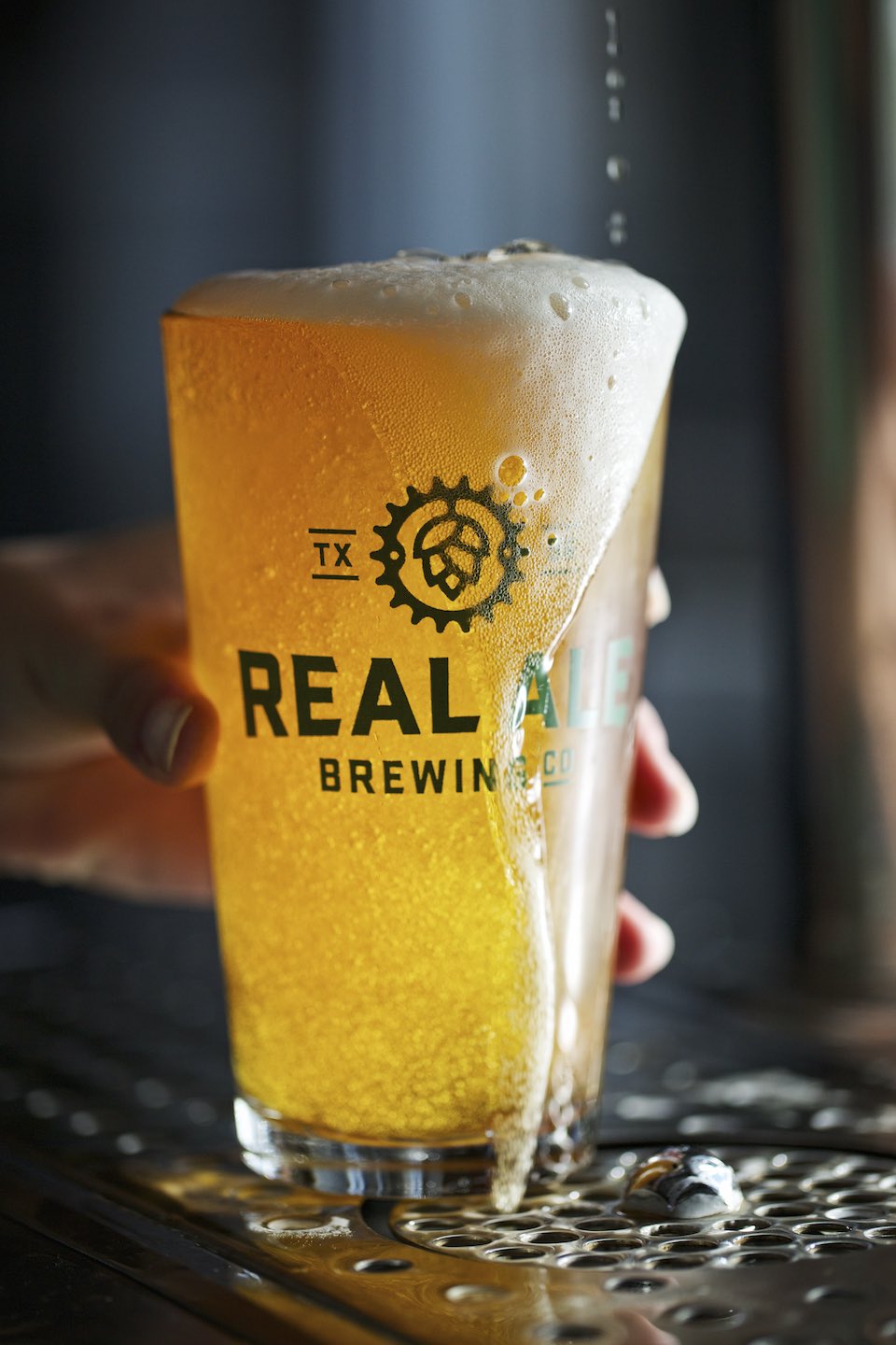 A light beer being poured on draft into a Real Ale Brewing Co. glass. 