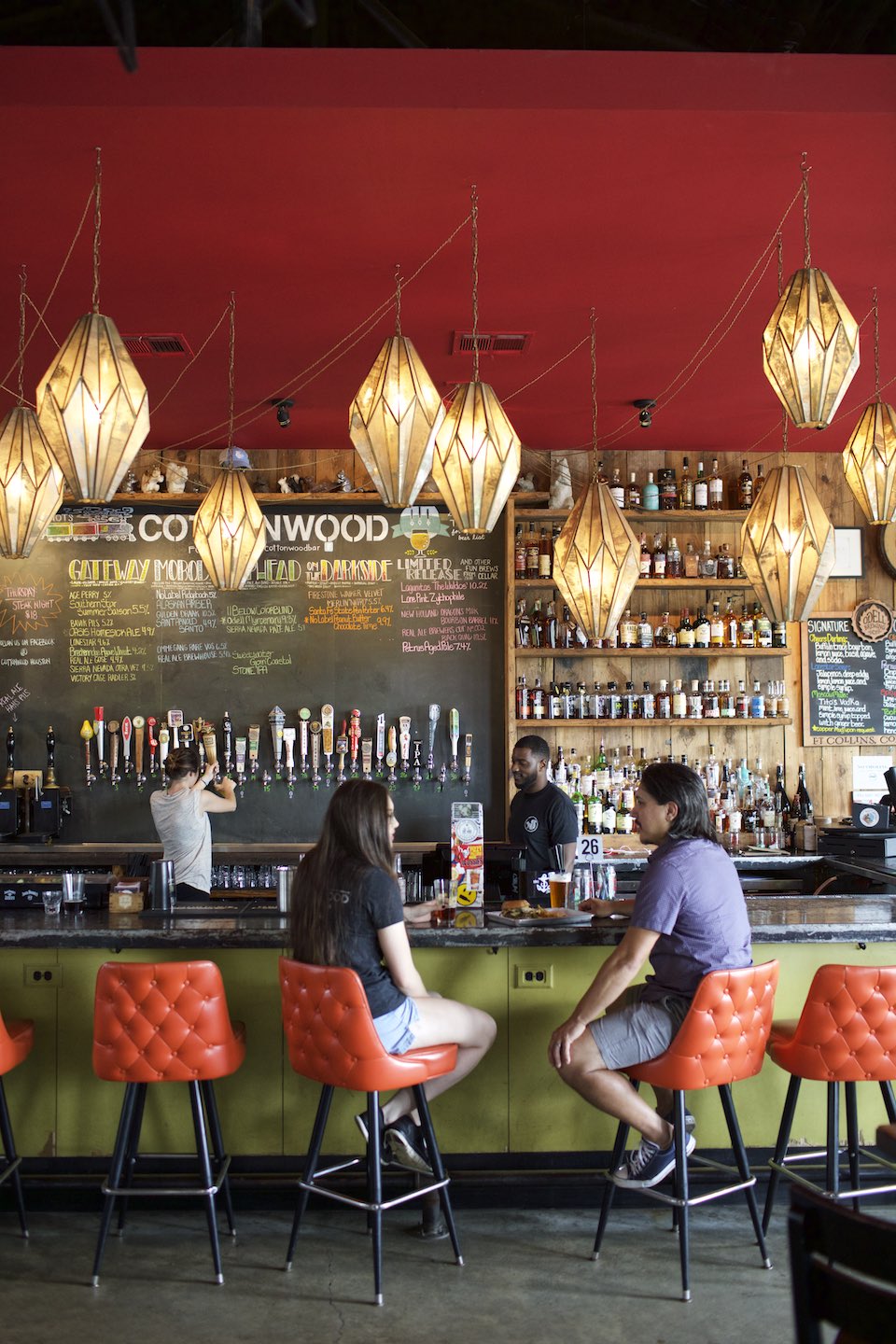 Chromatic bar scene with bartenders pouring beer and array of taps. 