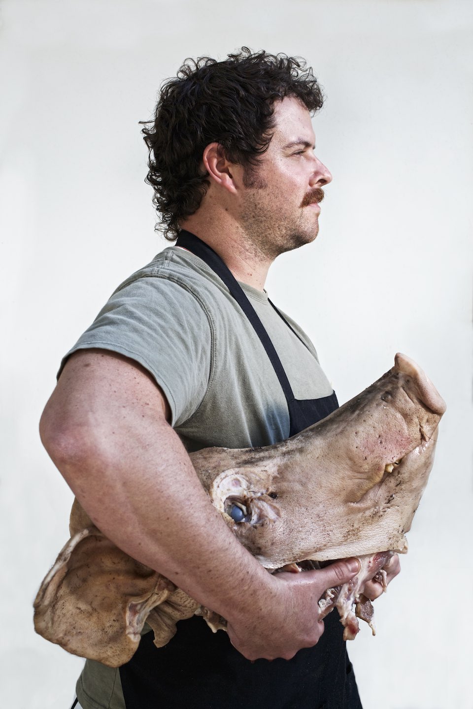 Profile of chef holding a pig