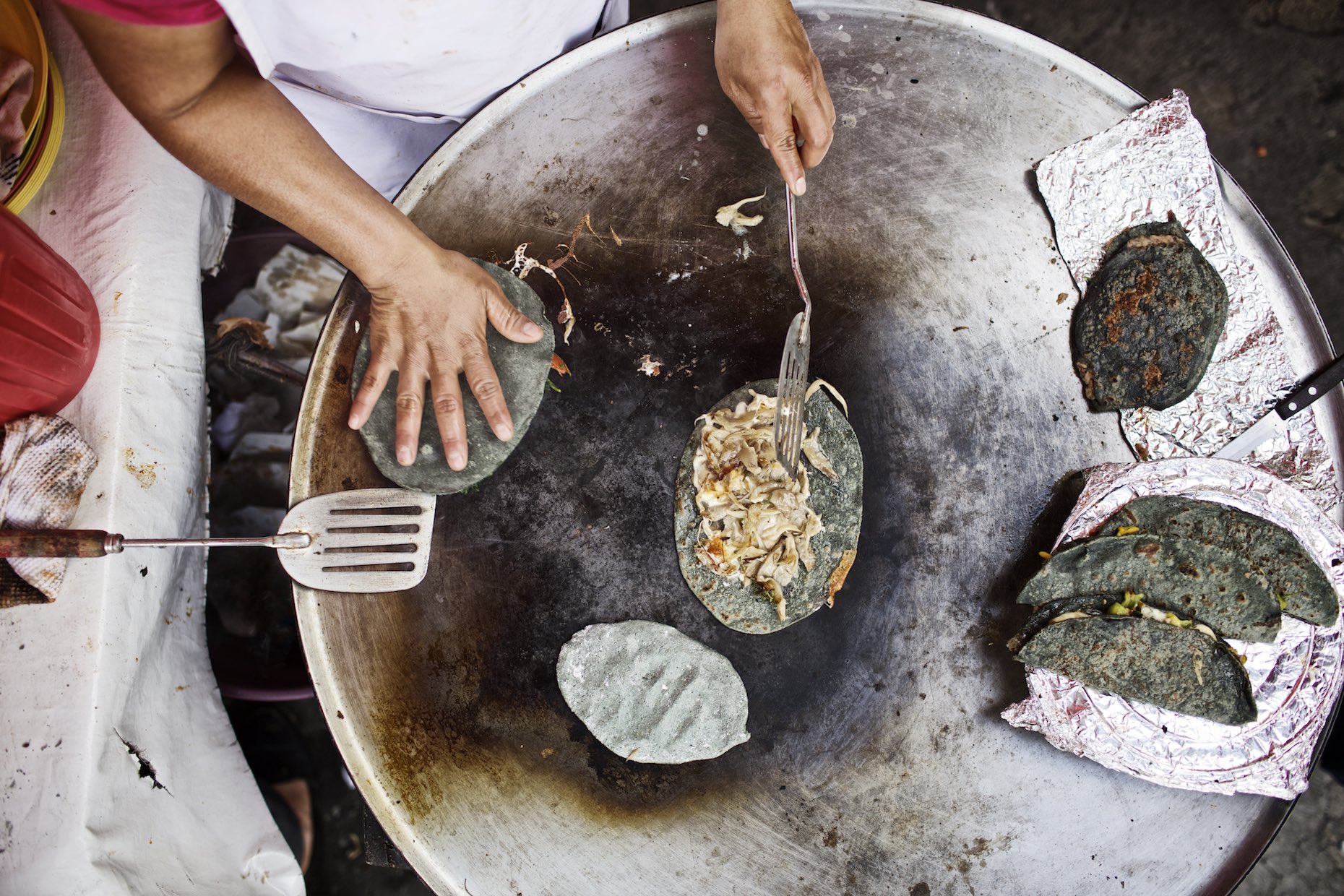 Blue corn tortillas with chicken being prepared on a Plancha. 