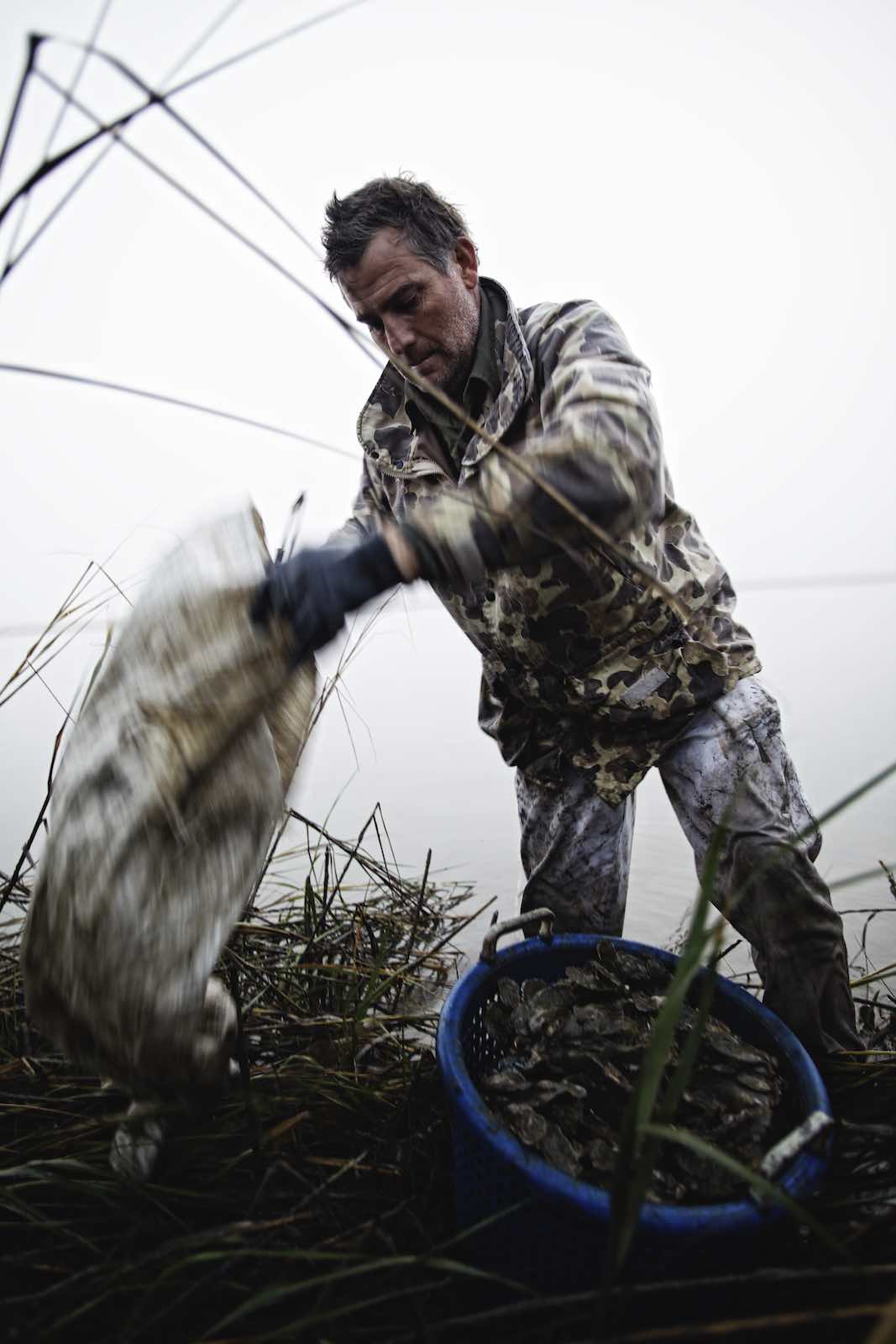Jody Horton Photography - Fisherman and basket of oysters during oyster harvest. 