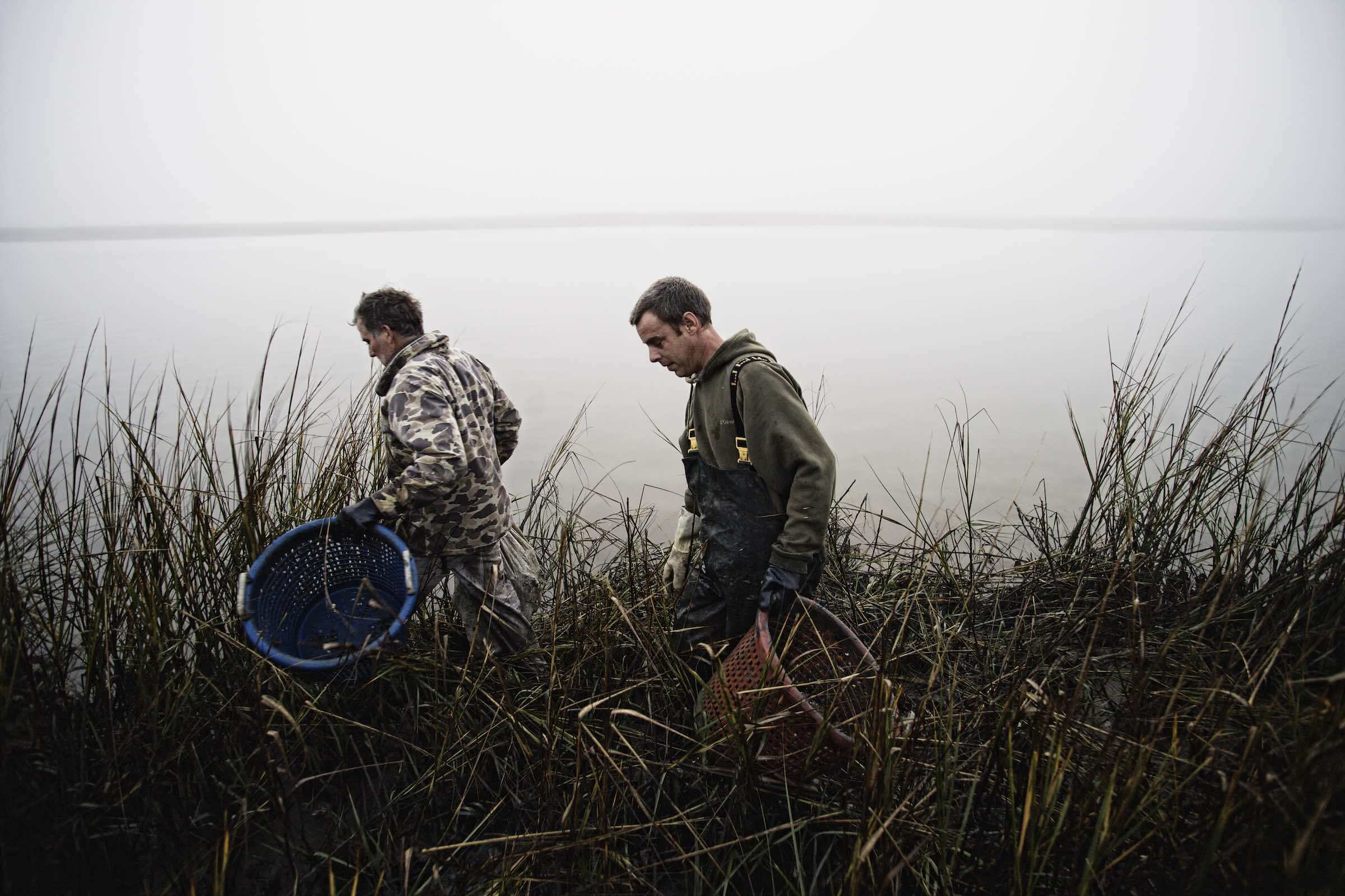 Jody Horton Photography - Fishermen carrying empty baskets through tall grass. 