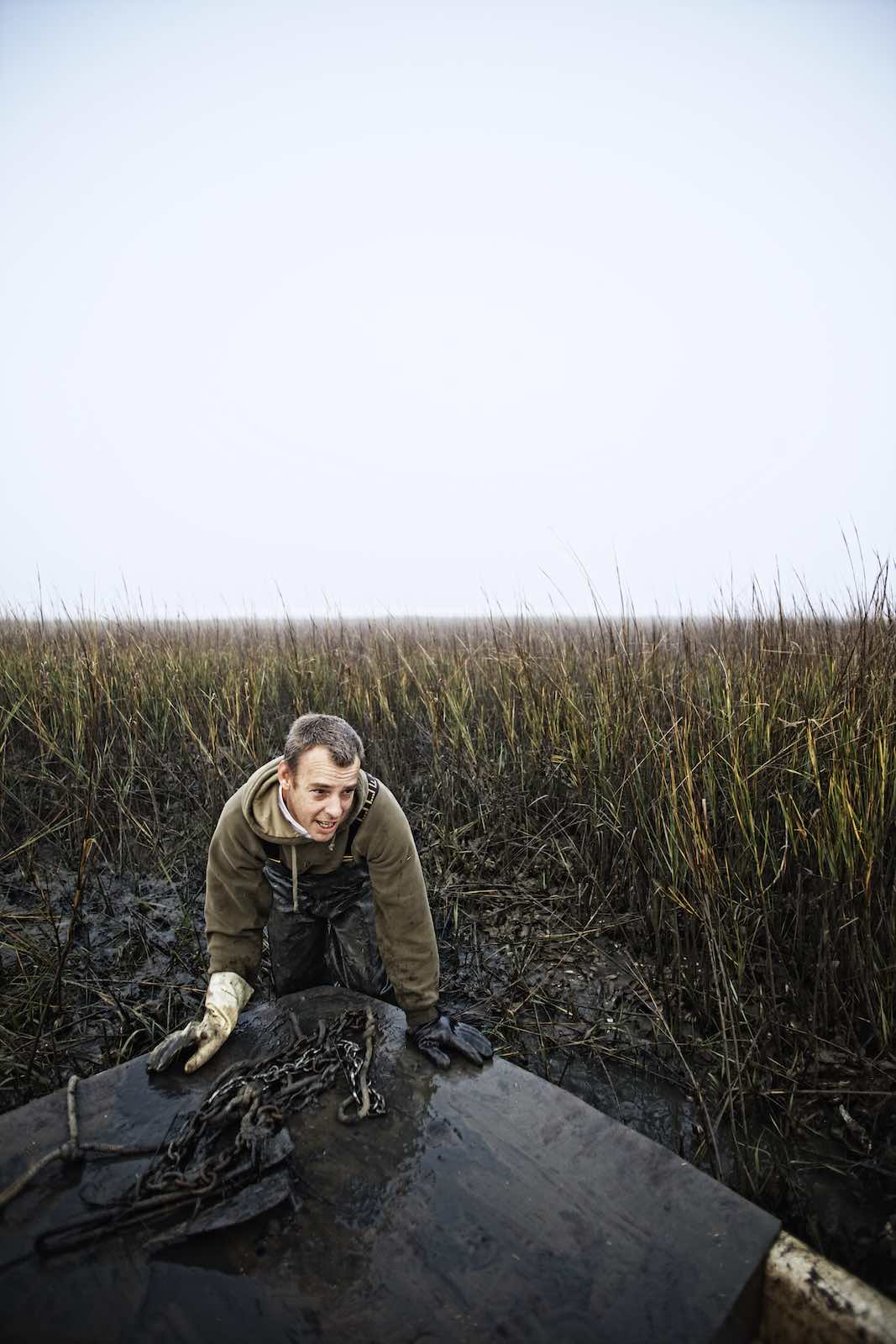 Jody Horton Photography - Fisherman pushing their boat away from the muddy shore. 