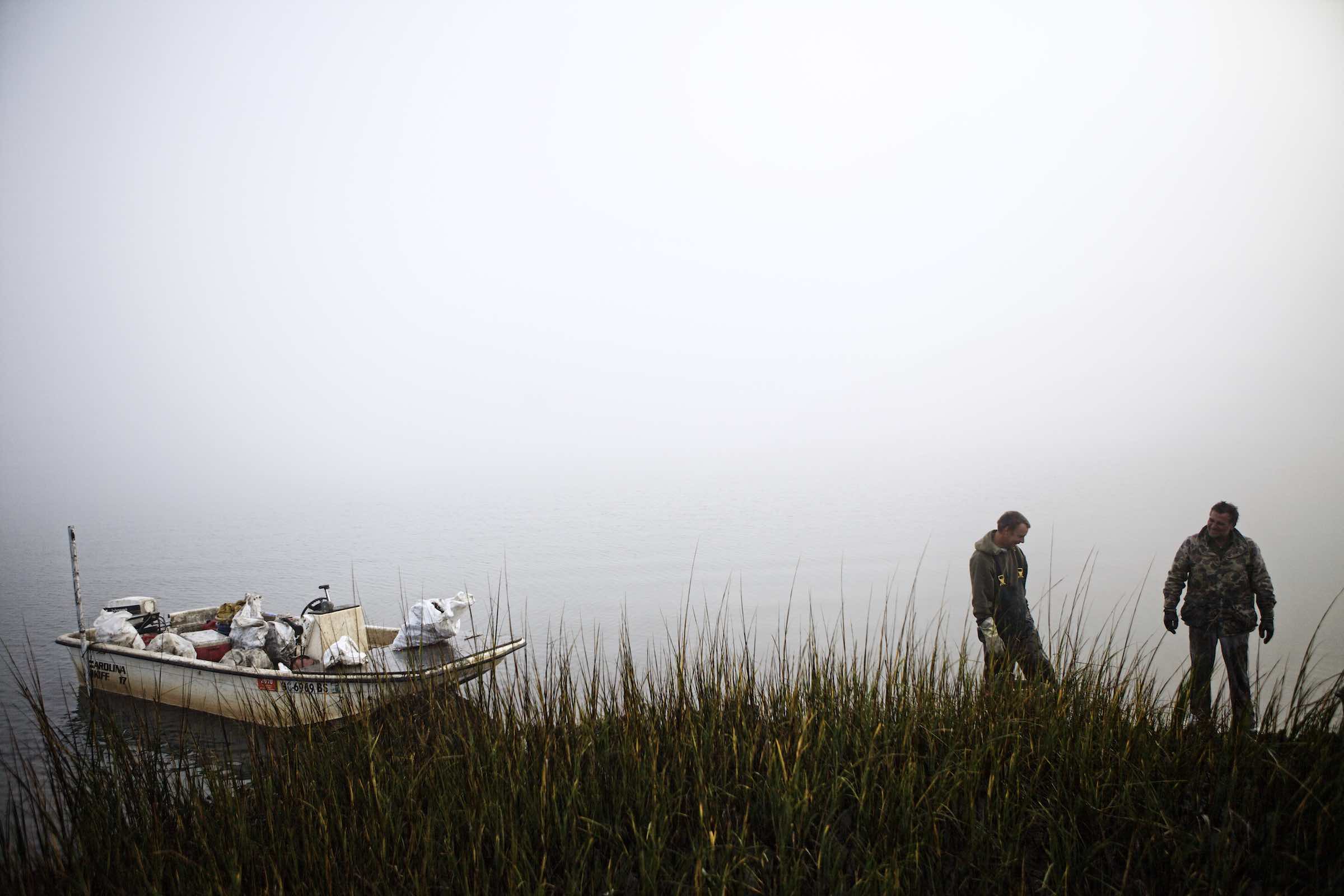 Jody Horton Photography - Fishermen and their boat standing behind tall marsh grasses. 