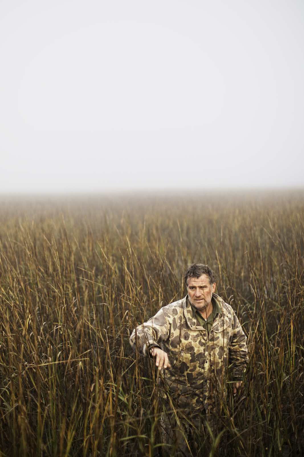 Jody Horton Photography - Fisherman navigating his way through tall, golden grasses. 