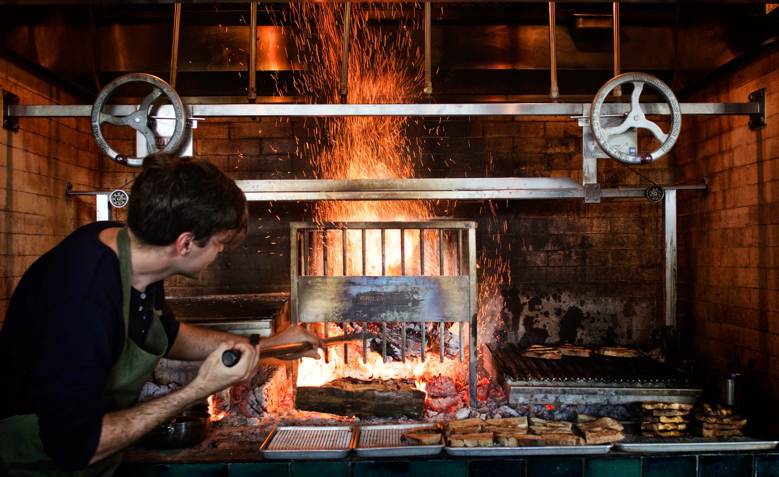 Jody Horton Photography - Chef stoking fire in brick oven. 