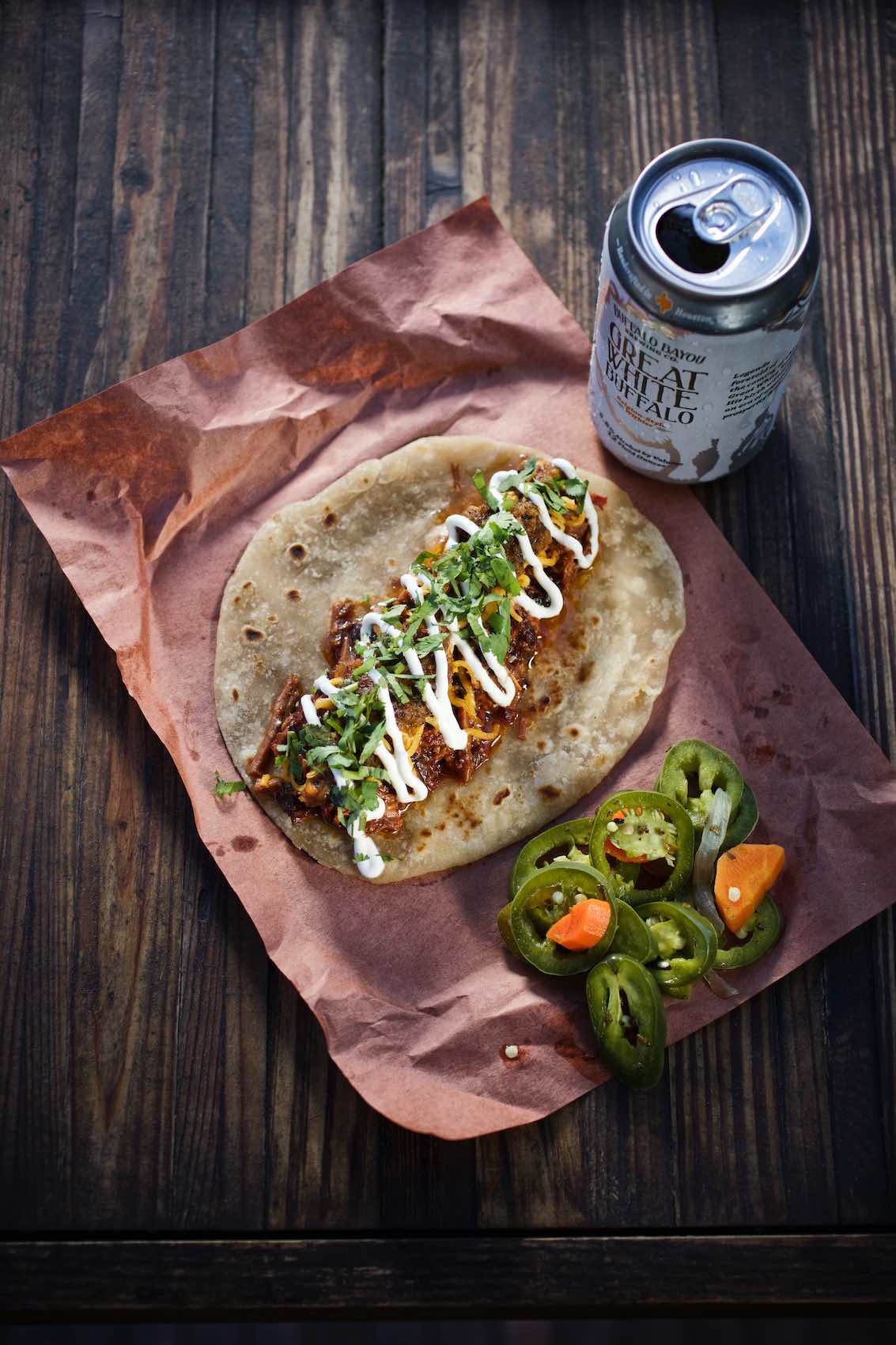 Jody Horton Photography -  Barbacoa taco on parchment with canned beer. 
