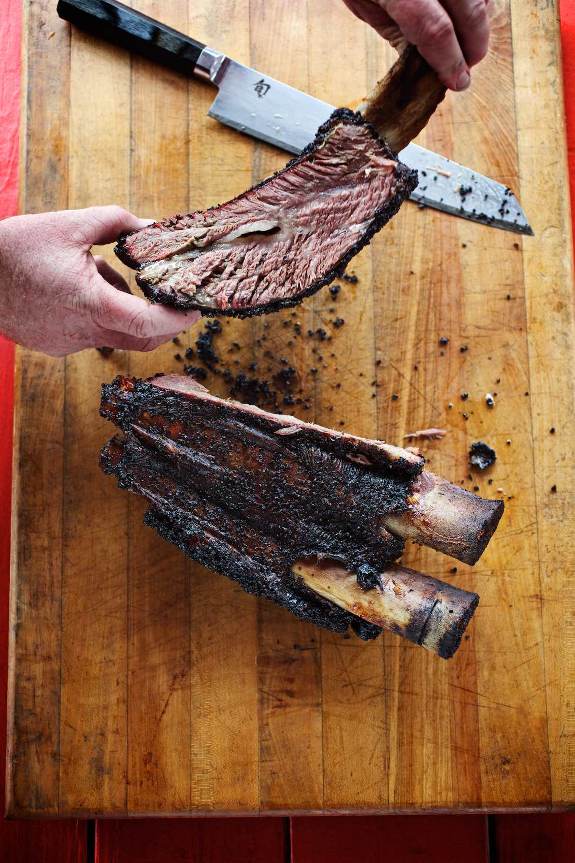 Jody Horton Photography - Barbecued ribs sliced on wood cutting board. 