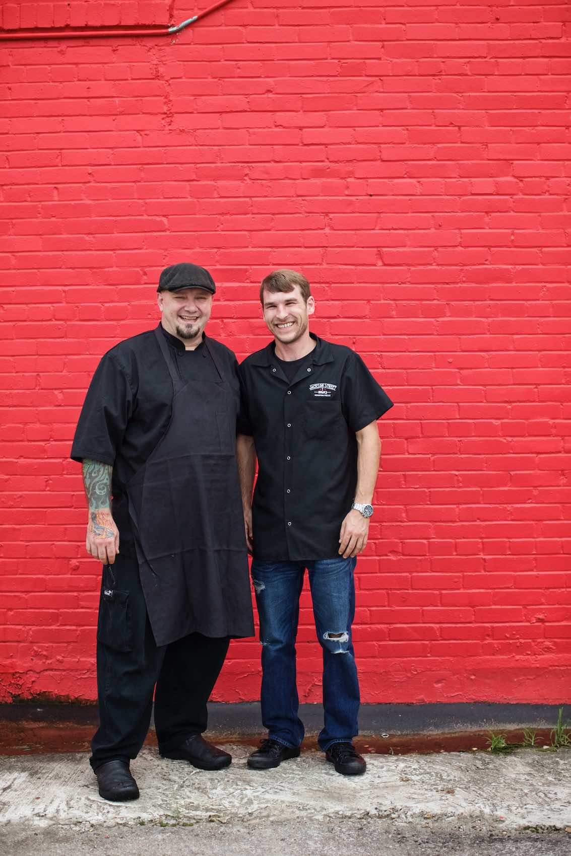 Jody Horton Photography - Chefs standing against painted red brick wall. 