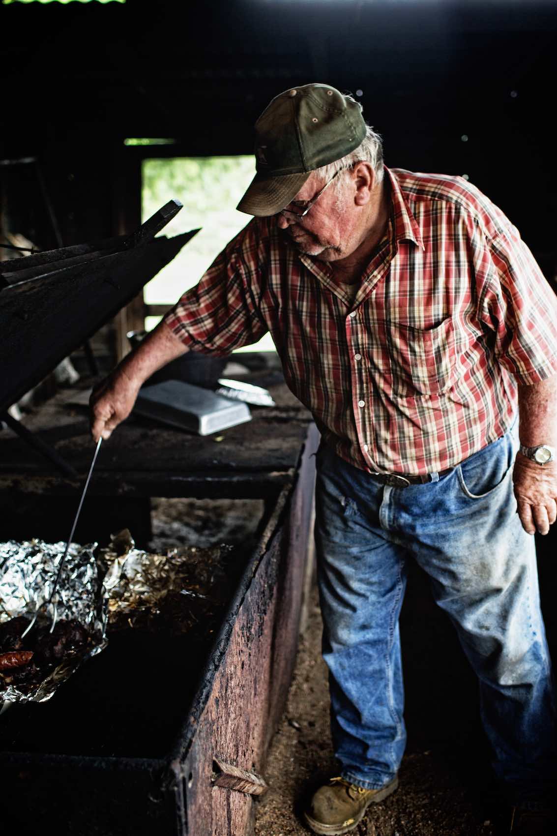 Jody Horton Photography - Man cooking meat in foil on smoker. 