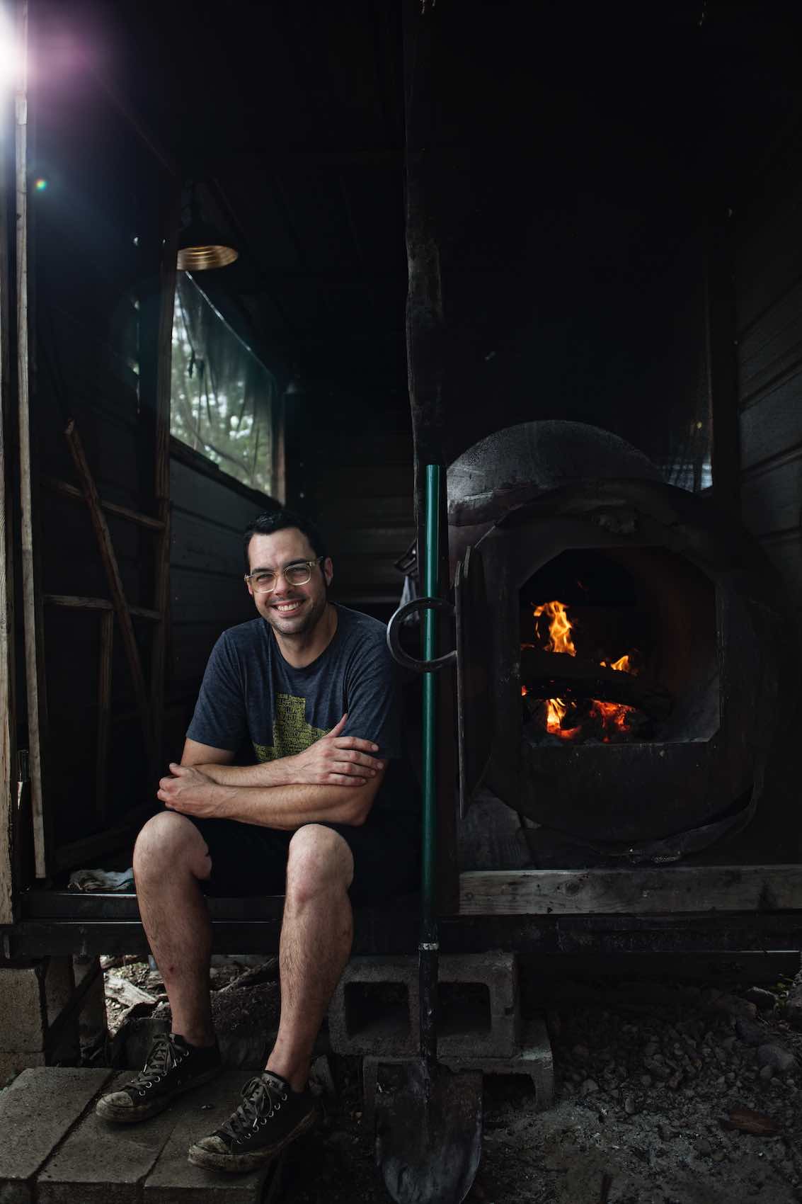 Jody Horton Photography - Aaron Franklin sitting next to barbecue smoker. 