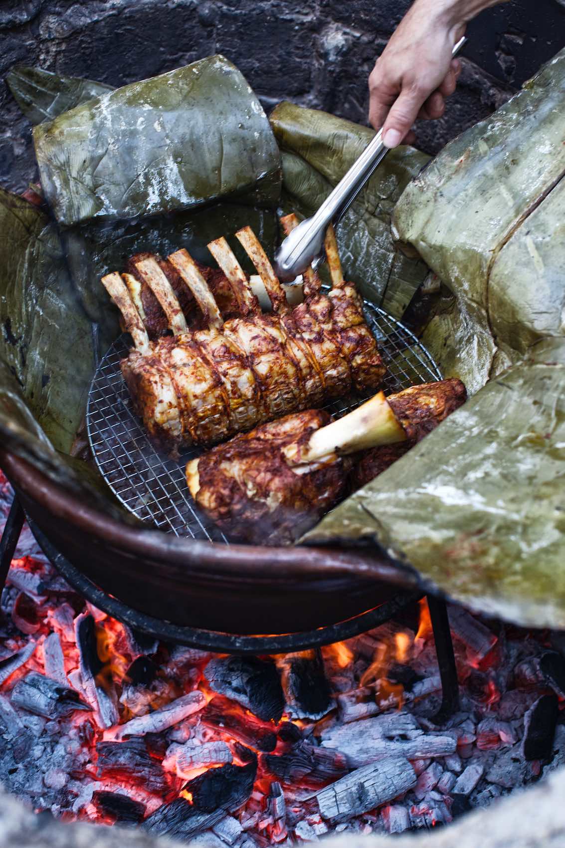 Jody Horton Photography - Meats cooking in leaves on outdoor fire. 