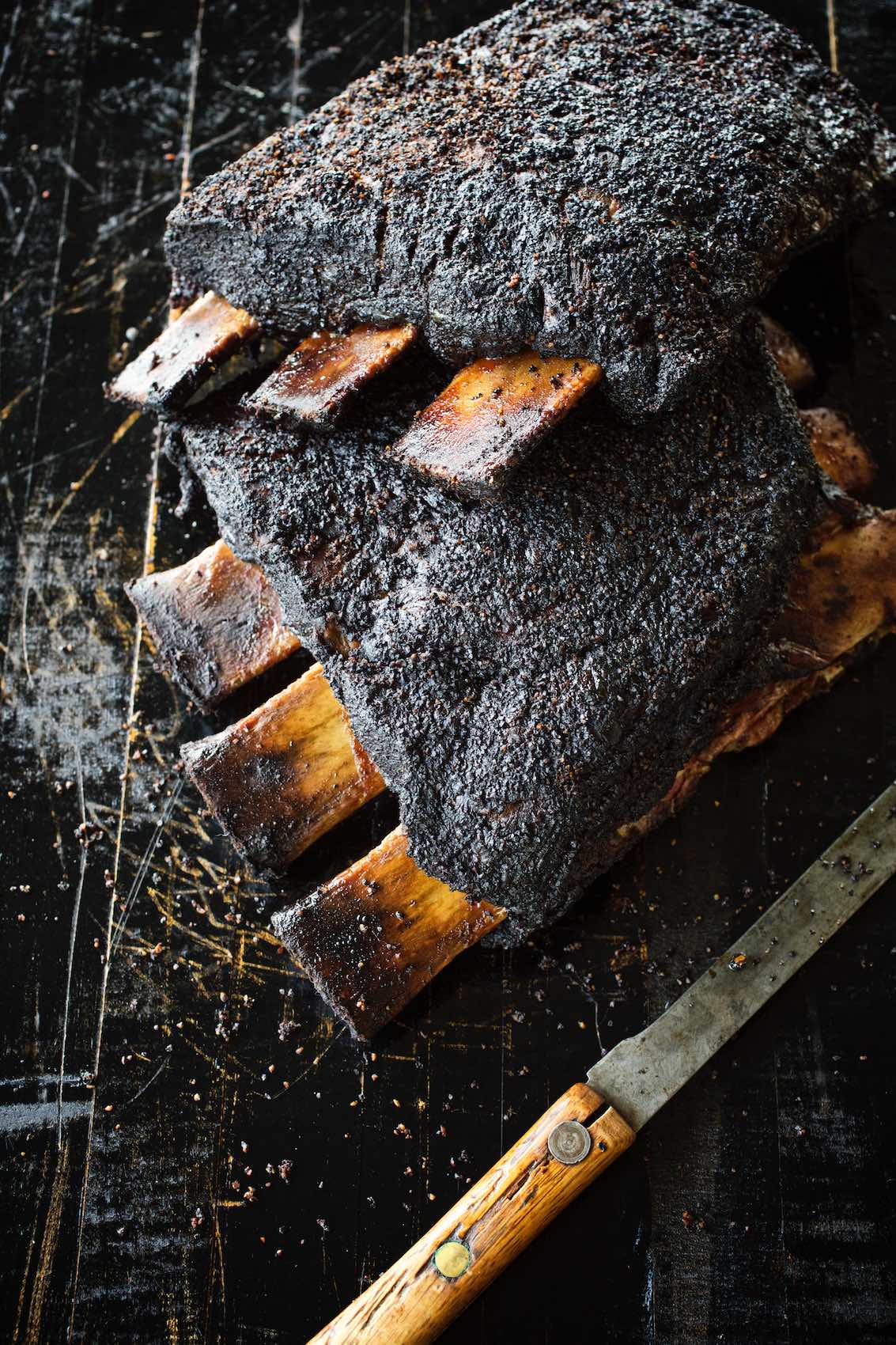Jody Horton Photography - Blackened ribs on cutting board with rustic knife.