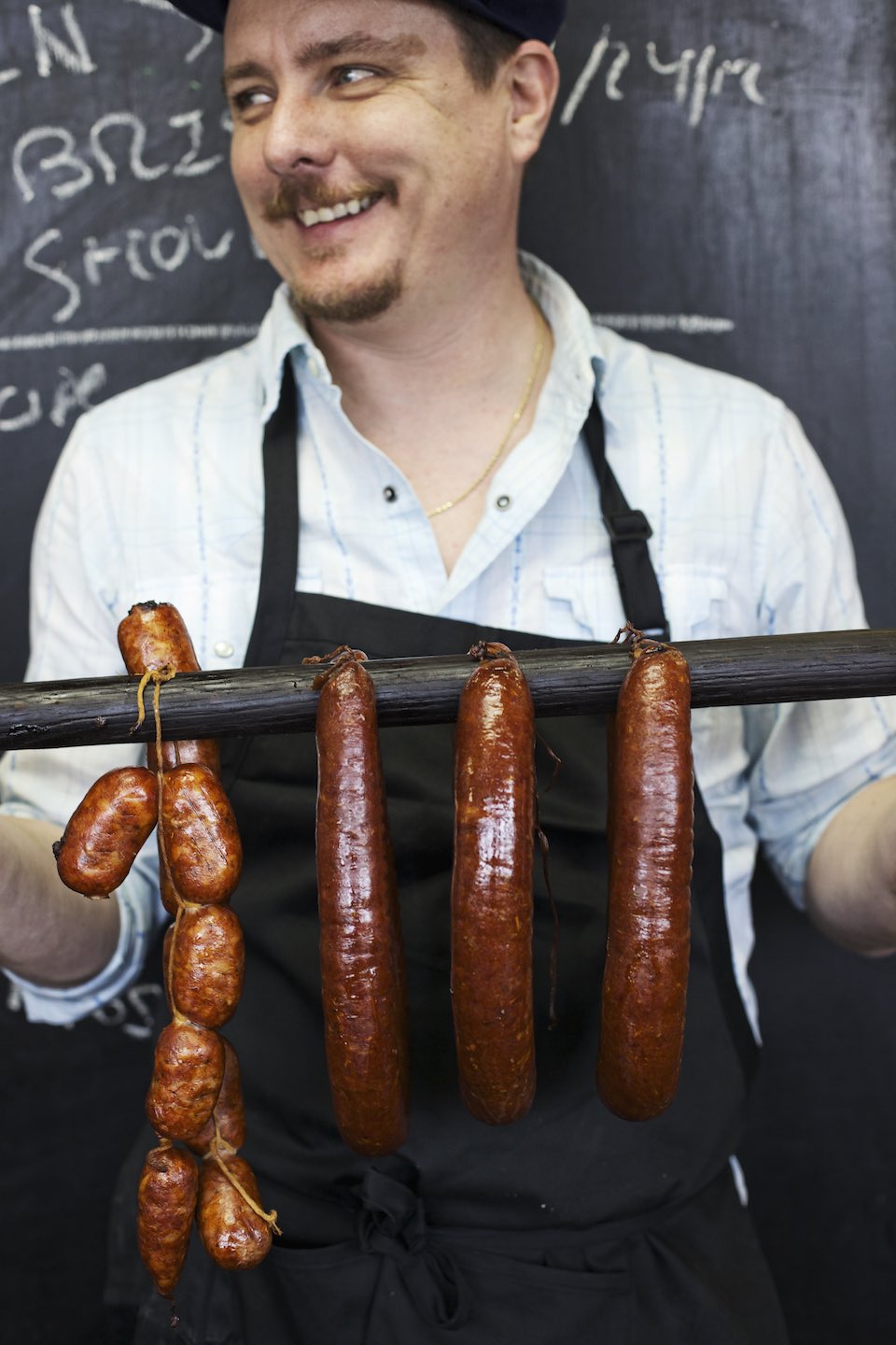 Jody Horton Photography - Chef Tim Byres holding presenting smoked sausages.