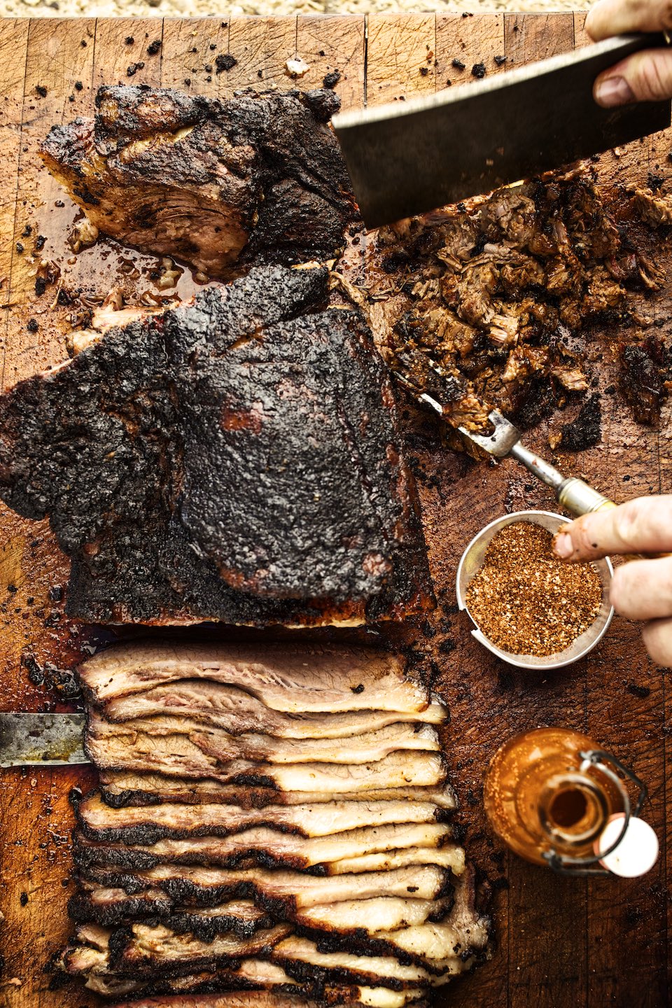 Jody Horton Photography - Sliced brisket and sauces on a wood cutting board.