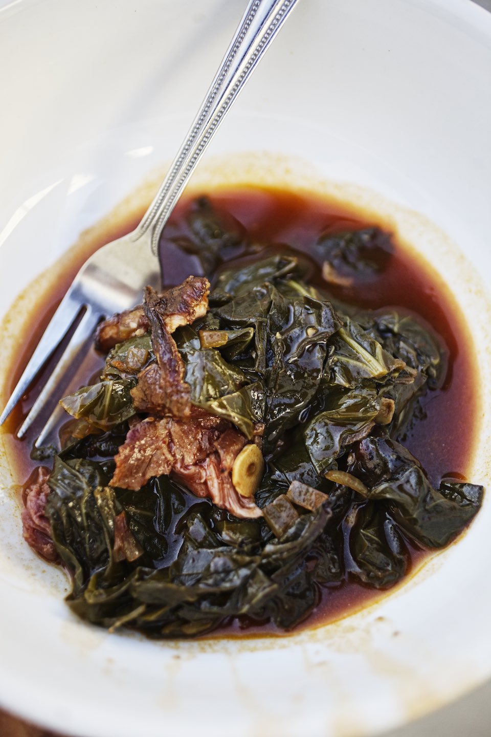 Jody Horton Photography - Stewed collards and meat in a shallow bowl.