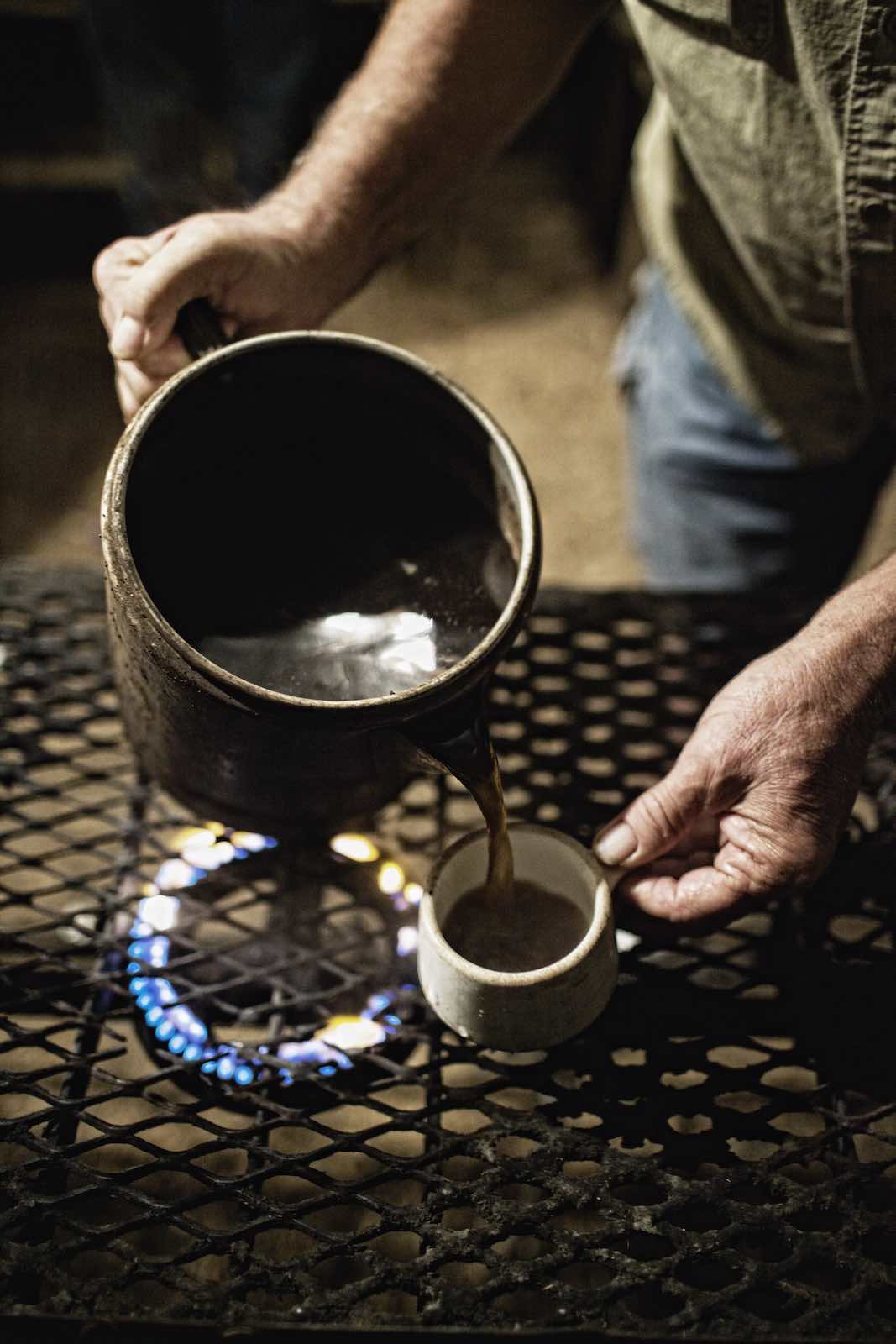 Jody Horton Photography - Coffee heating on a stove in a pitcher and pouring into a small mug. 