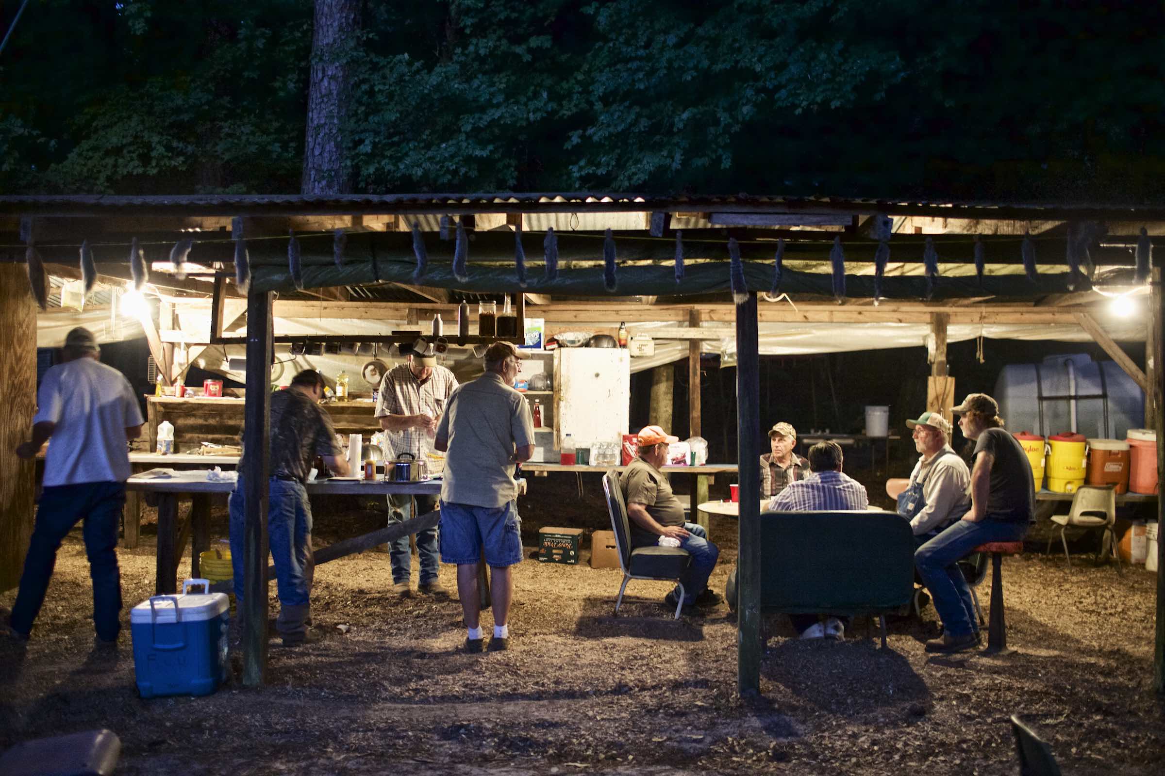 Jody Horton Photography - Hunters cooking and drinking in an open camp kitchen in the early morning.