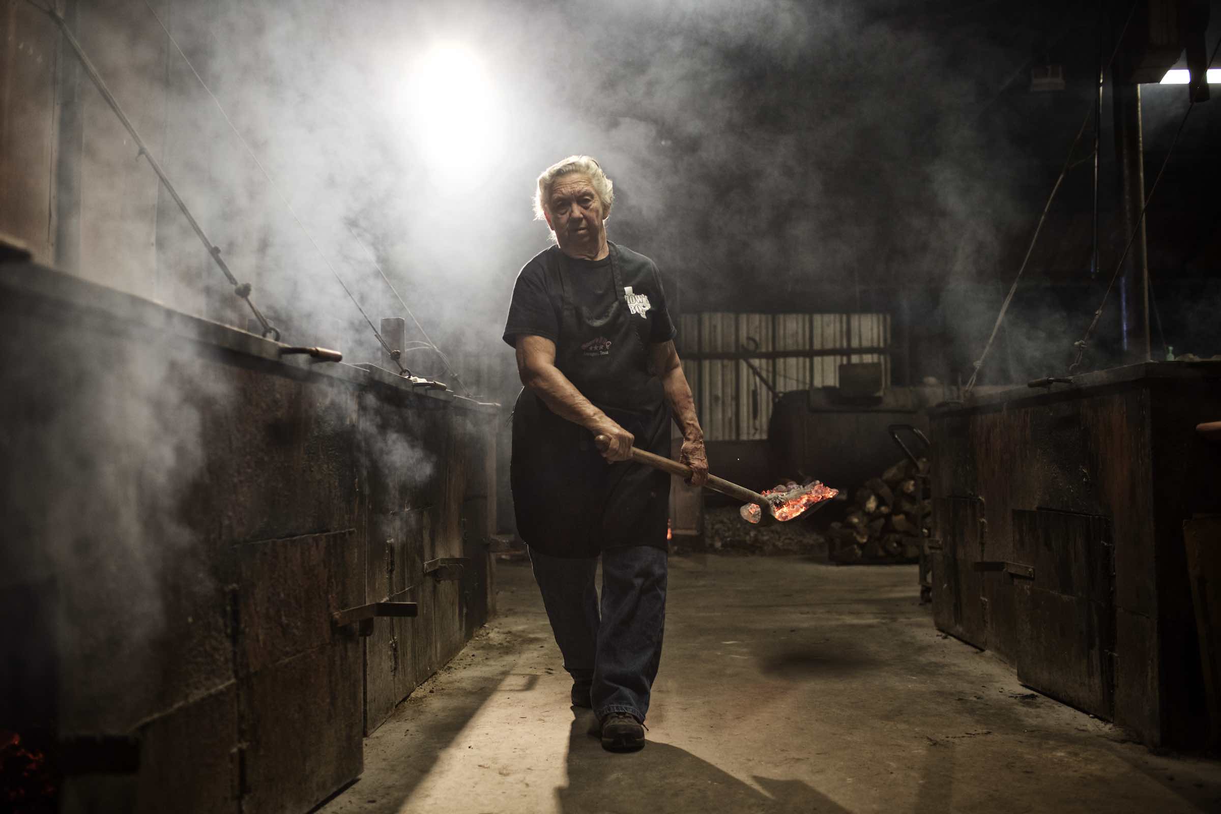 Jody Horton Photography - Pit master carrying hot coals on a shovel. 